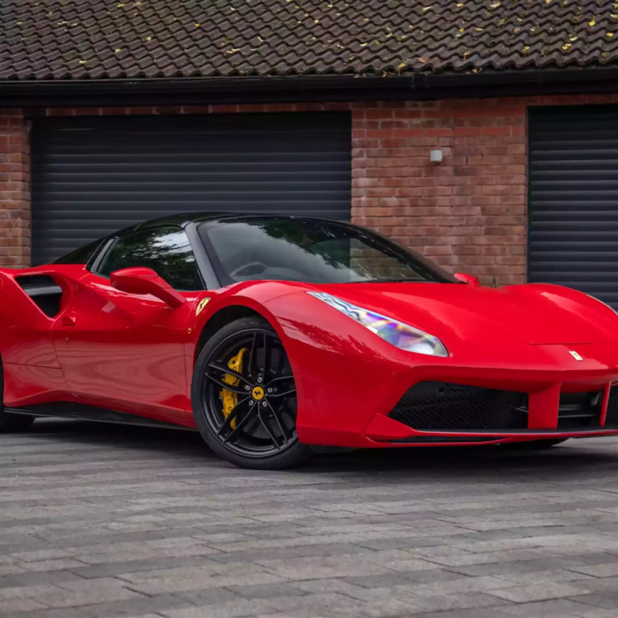 Red sports car parked in front of a brick building