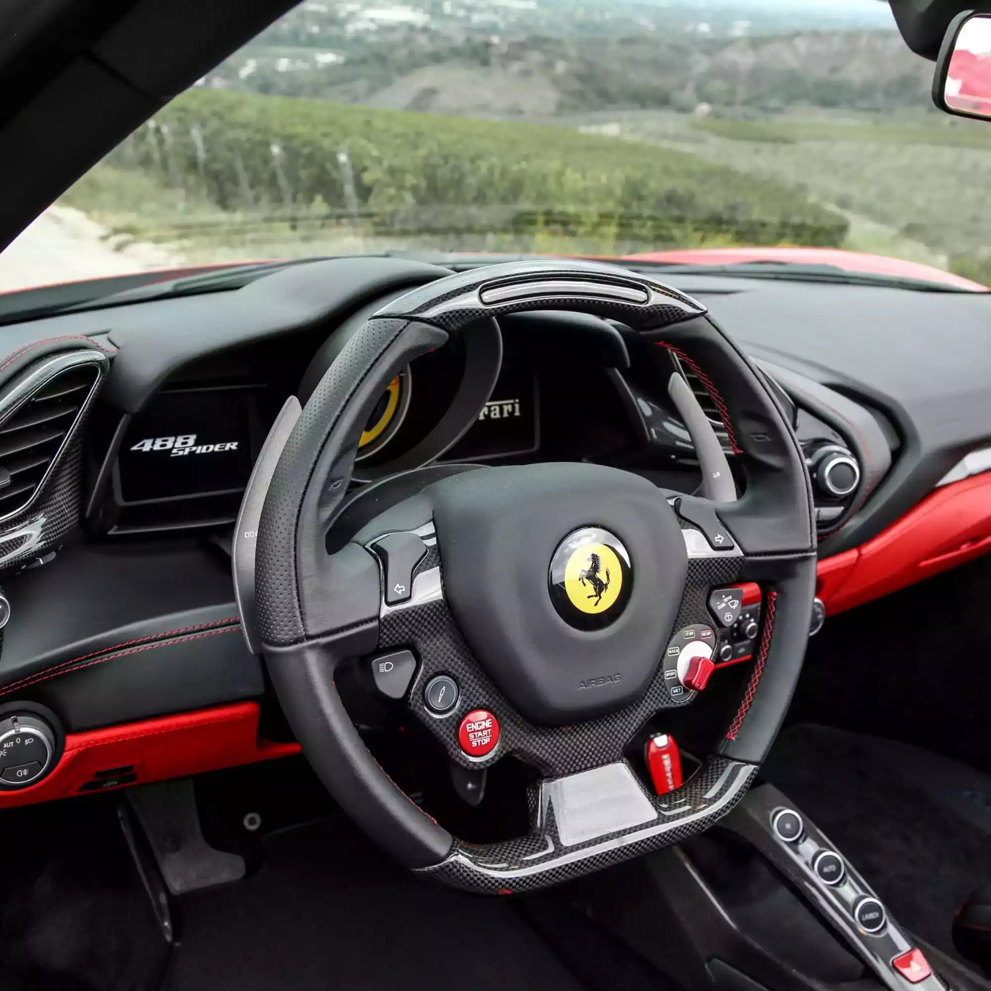 Steering wheel of a Ferrari car with a scenic background