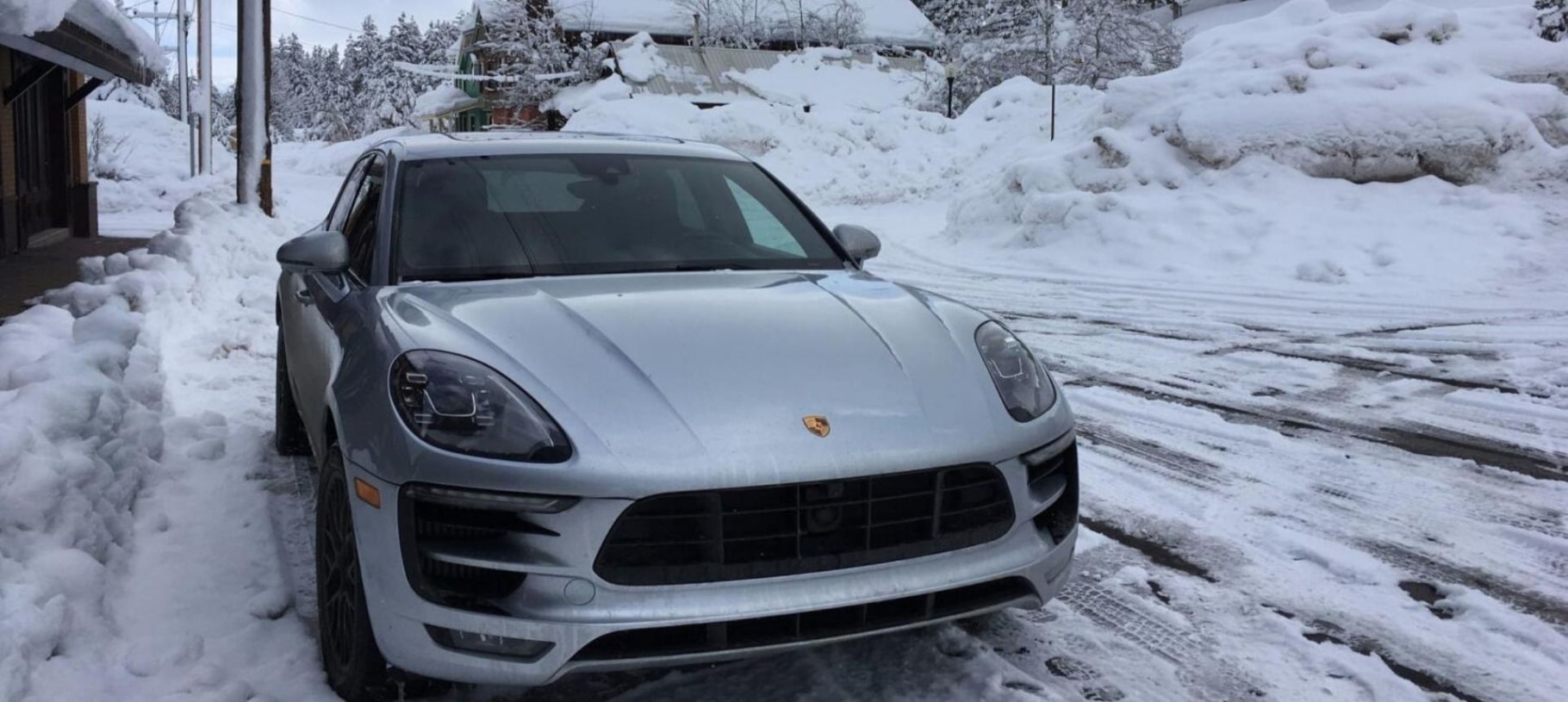 Silver Porsche SUV parked on a snow-covered street
