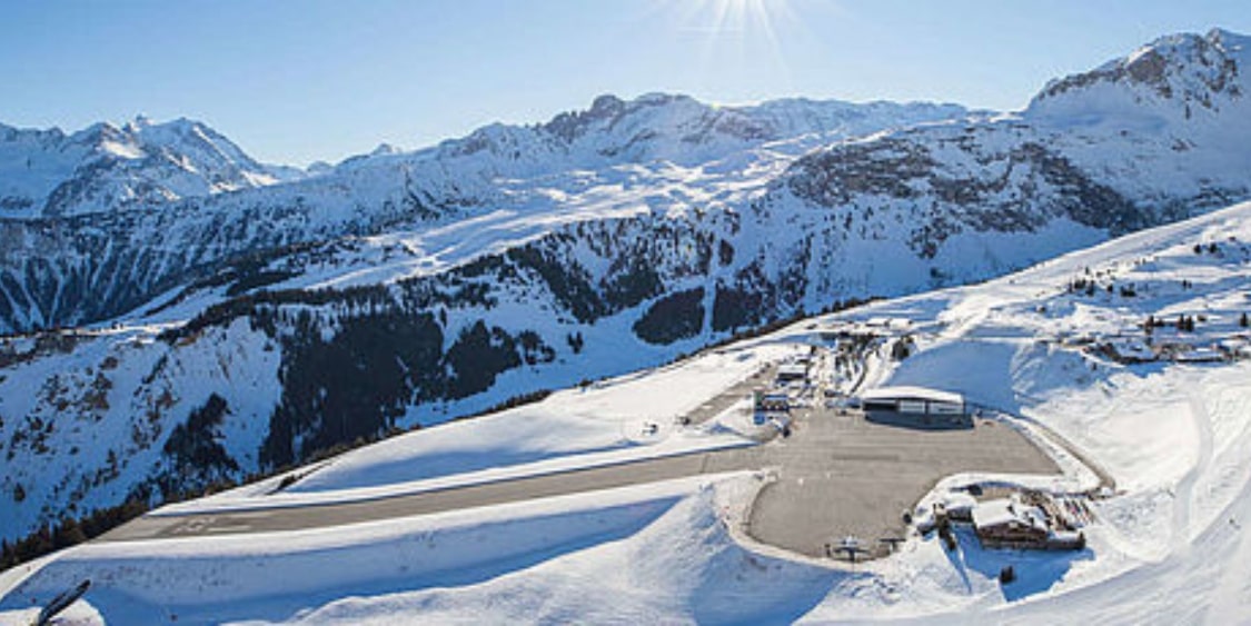 Snowy mountain landscape with a ski lift and mountains in the background