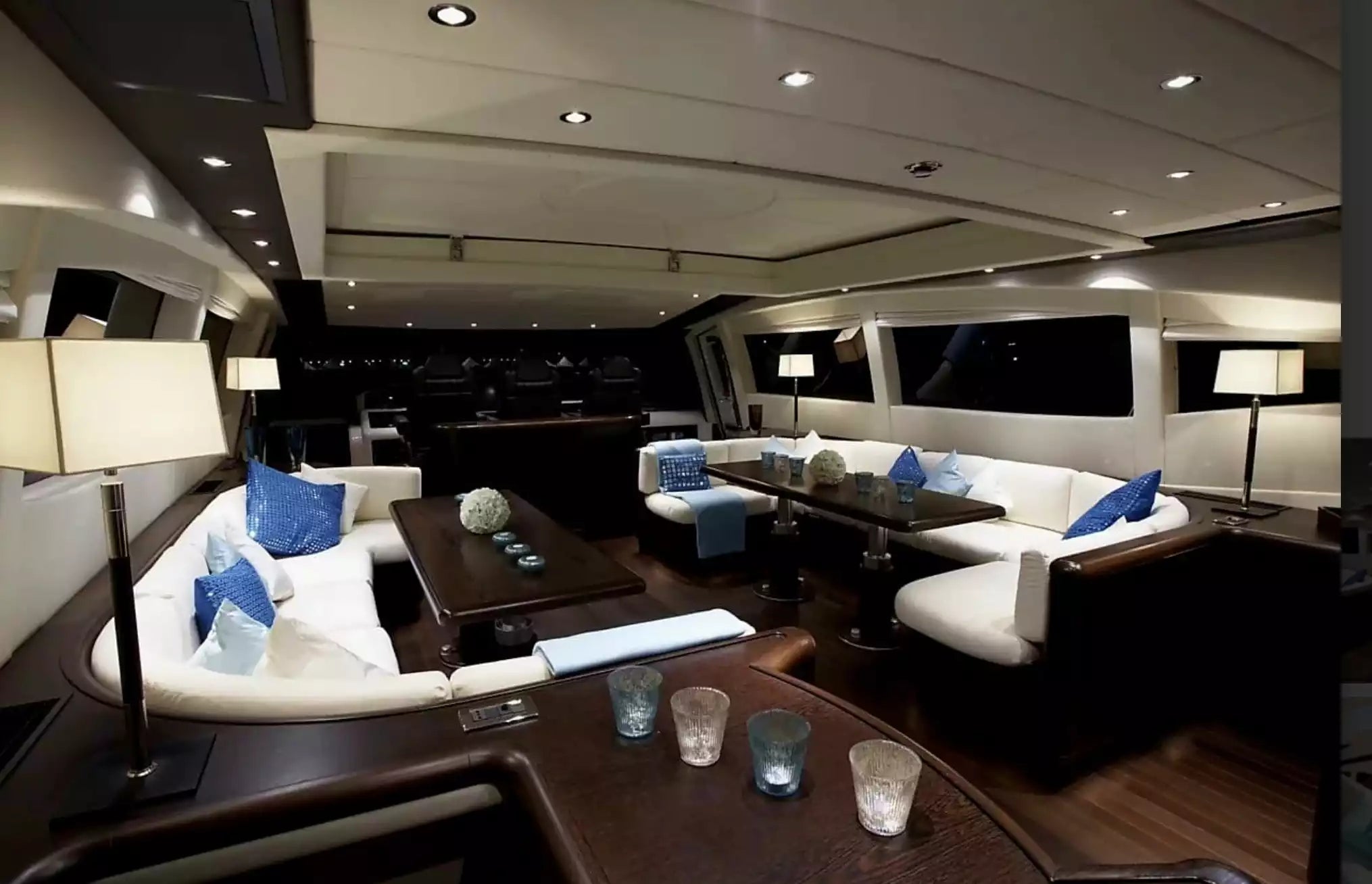 Luxury yacht interior with seating area, tables, and decor