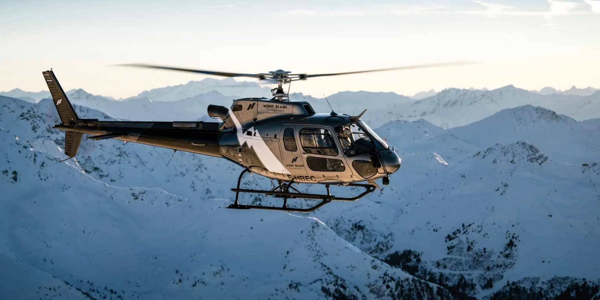 Helicopter flying over a snowy mountain landscape