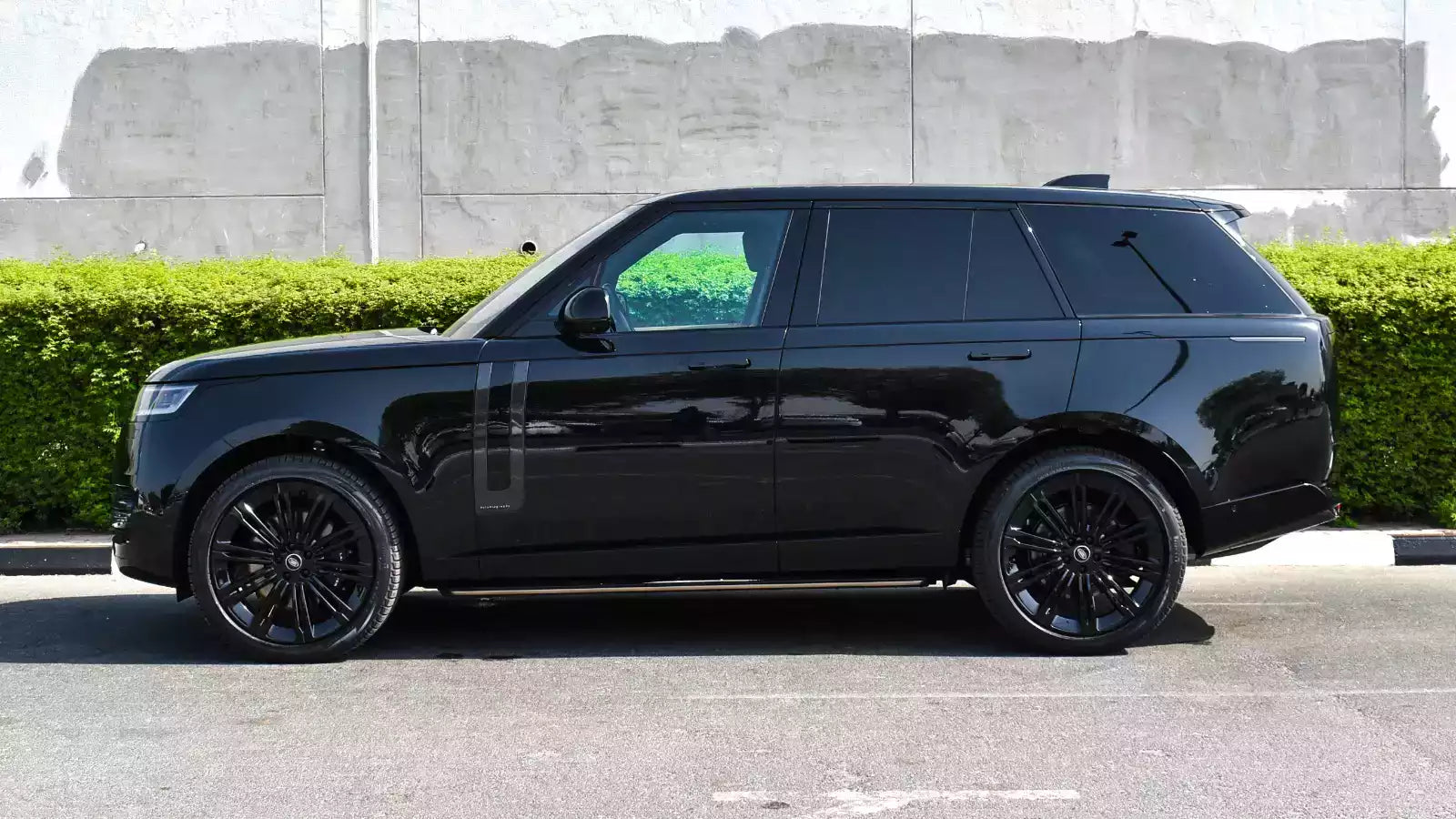 Black SUV parked on a street with a modern building in the background