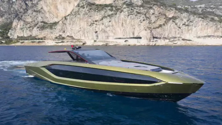 Modern green yacht on the water with a mountainous background