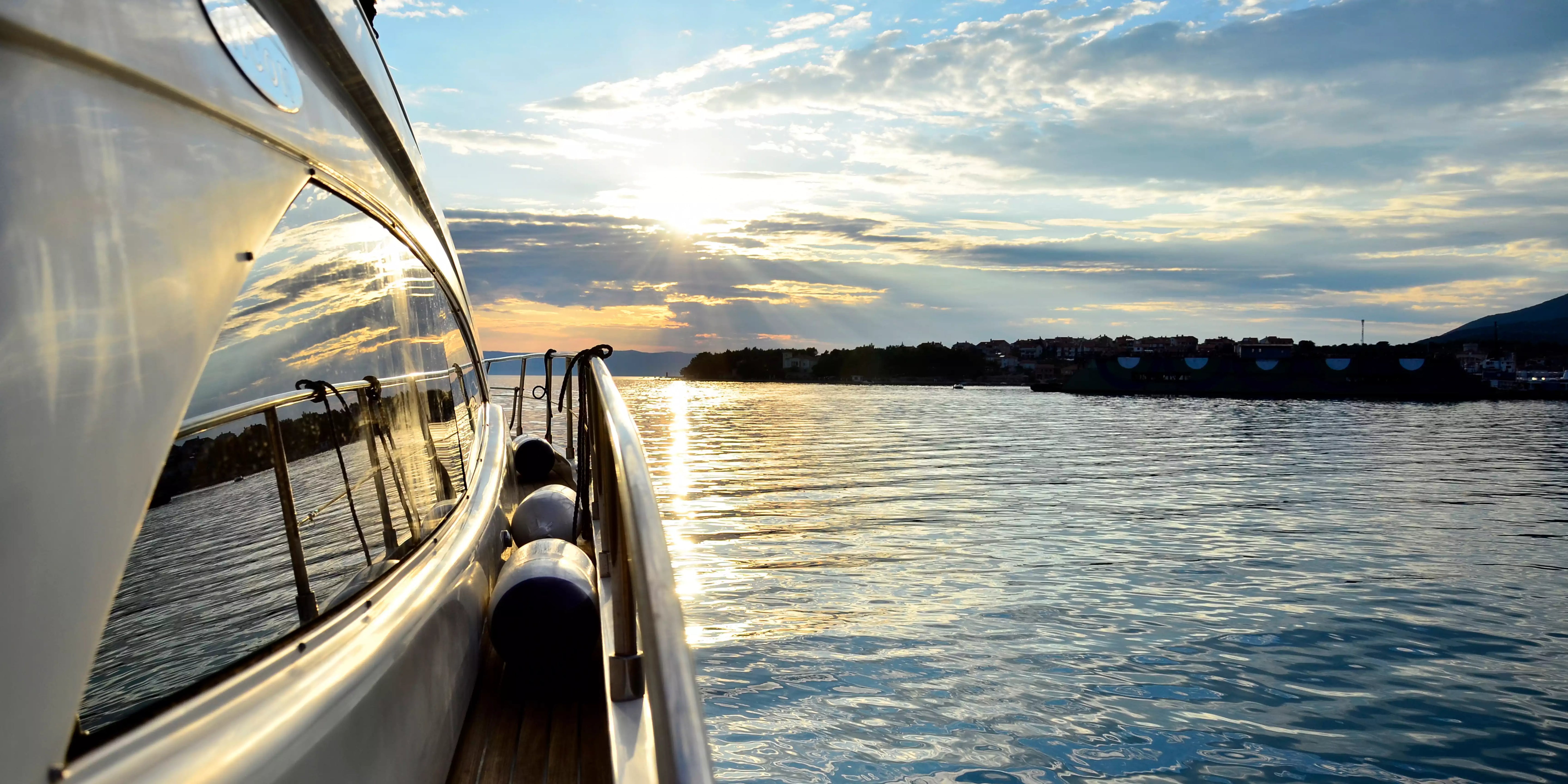 Yacht on a body of water with a scenic sunset in the background