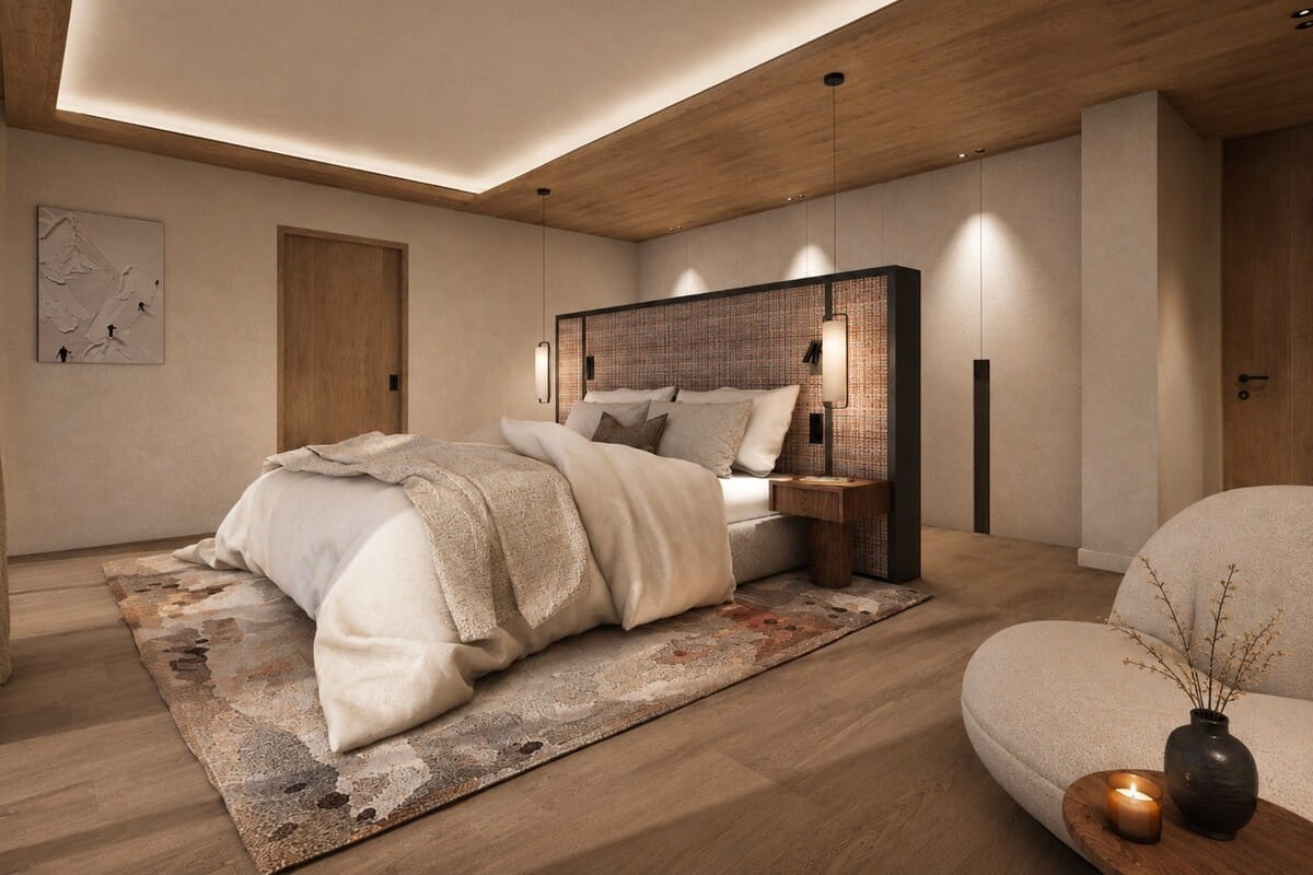 A modern bedroom interior featuring a bed dressed in cream bedding, a large patterned area rug, a dark wood headboard, warm wood ceiling and flooring, and ambient wall lighting. A curved upholstered chair and small side table with a candle are visible in the foreground.