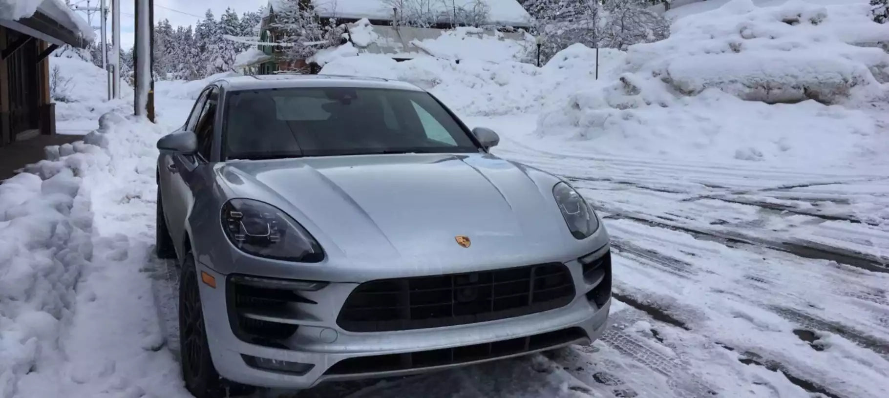 White Porsche SUV parked on a snow-covered street
