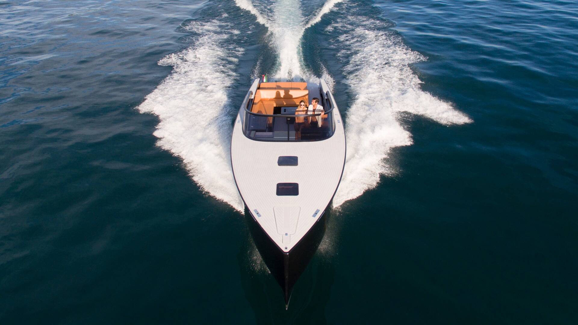 Speedboat cutting through water with a clear sky above