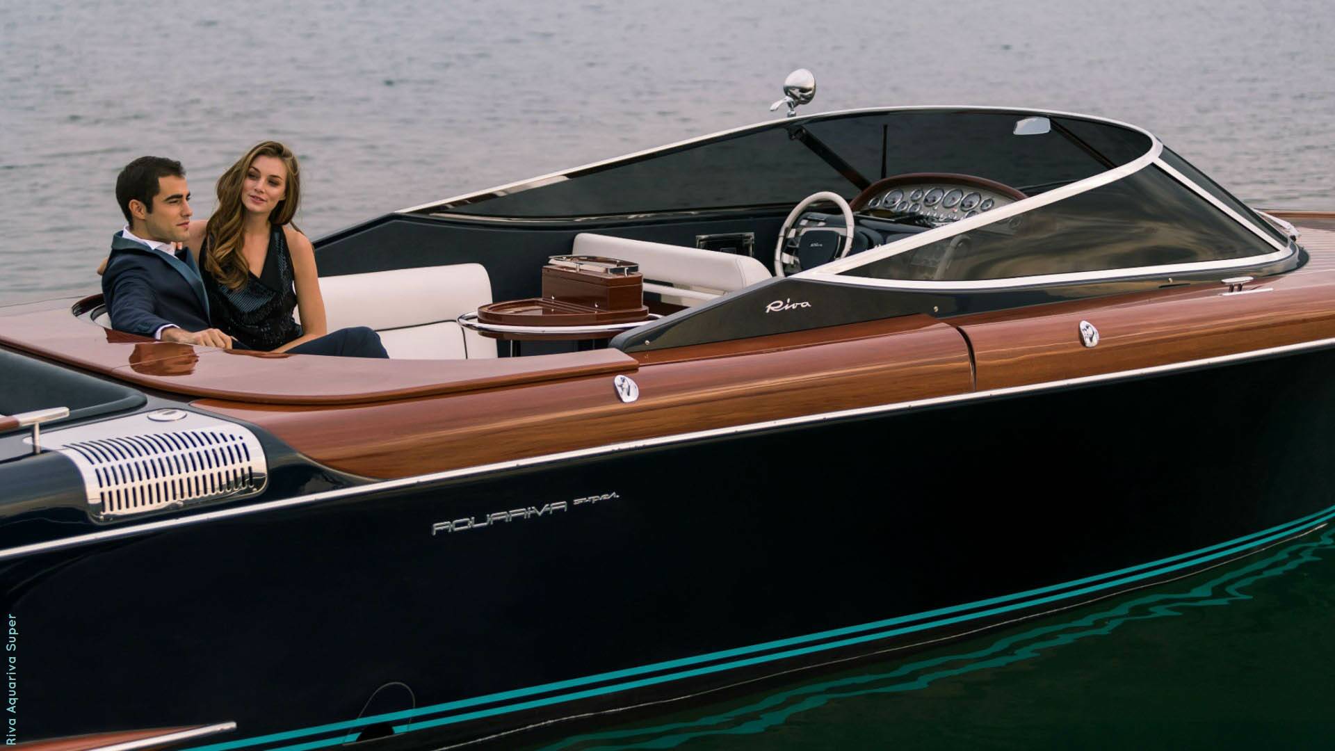 Luxury boat with a couple on board, featuring wood paneling and a sleek design.