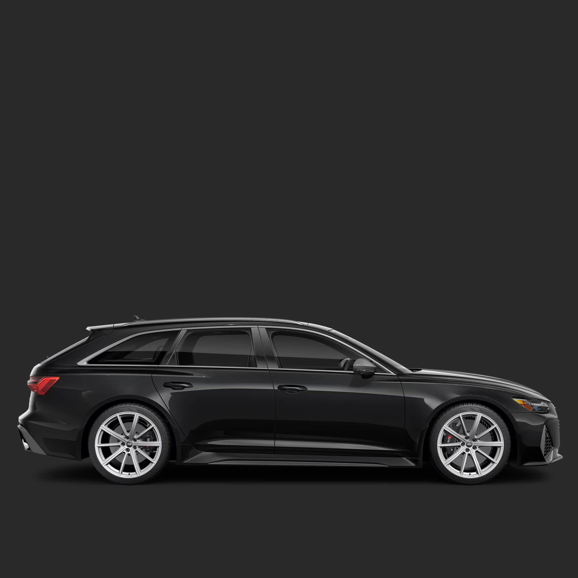 A side profile view of a black station wagon with silver multi-spoke wheels, shown against a solid dark gray background.