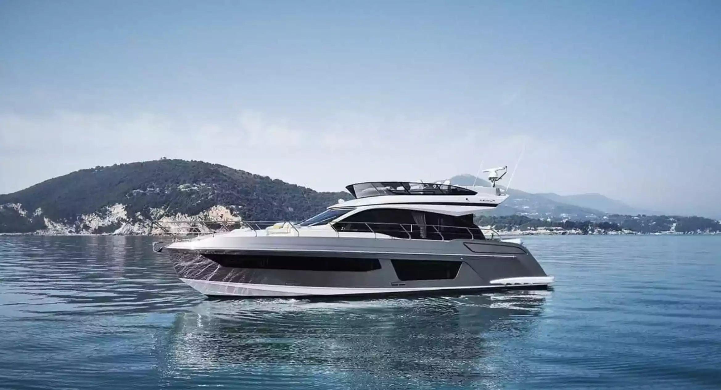 Luxury yacht on the water with a mountainous landscape in the background