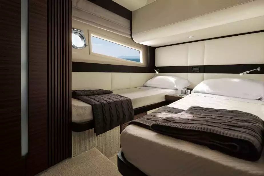 Yacht cabin with two beds and a window view of water