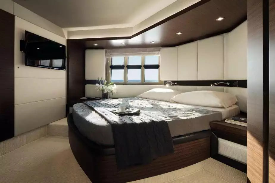 Modern bedroom with a bed, television, and window view.