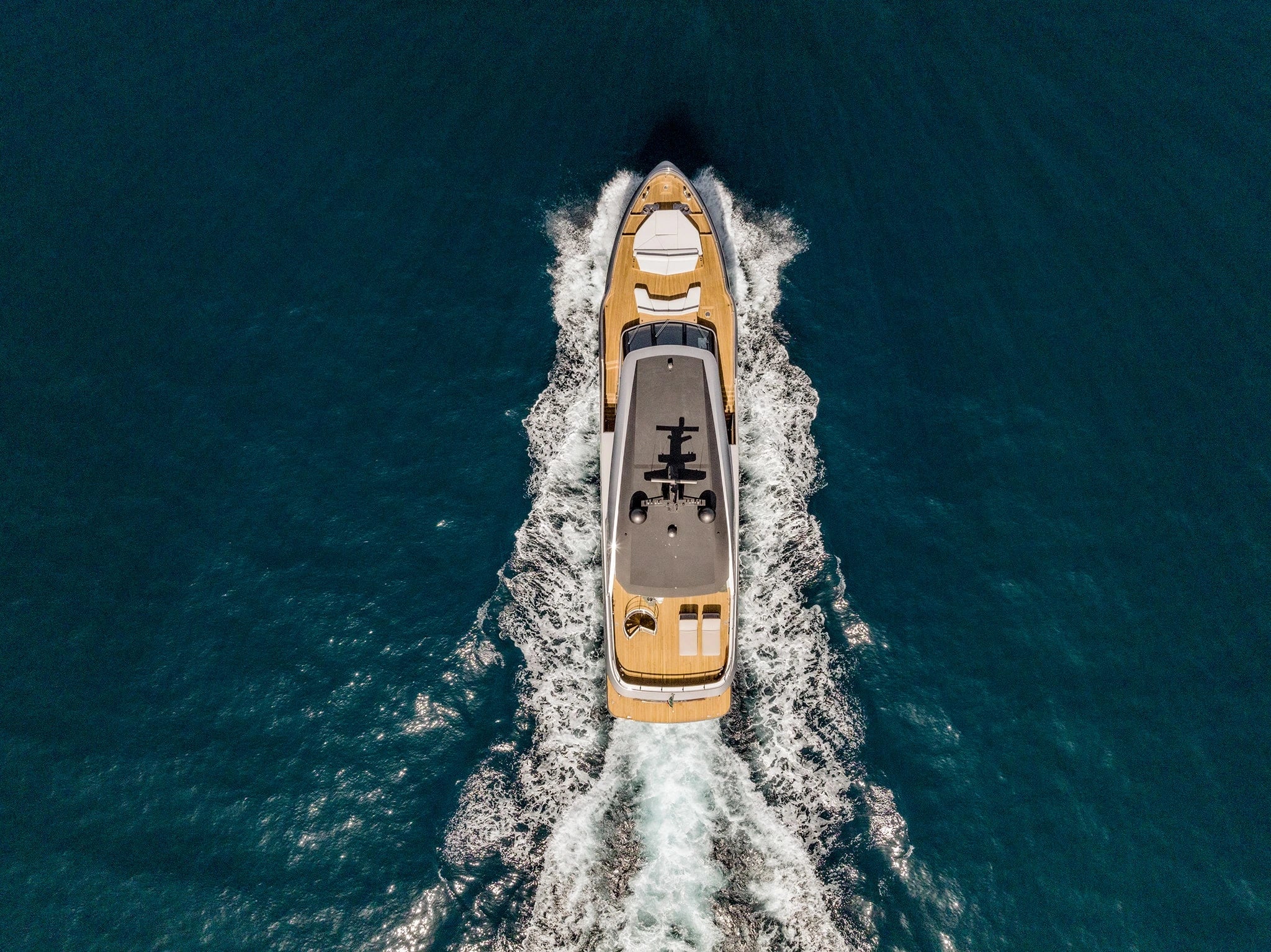 Aerial view of a luxury yacht speeding across the ocean.