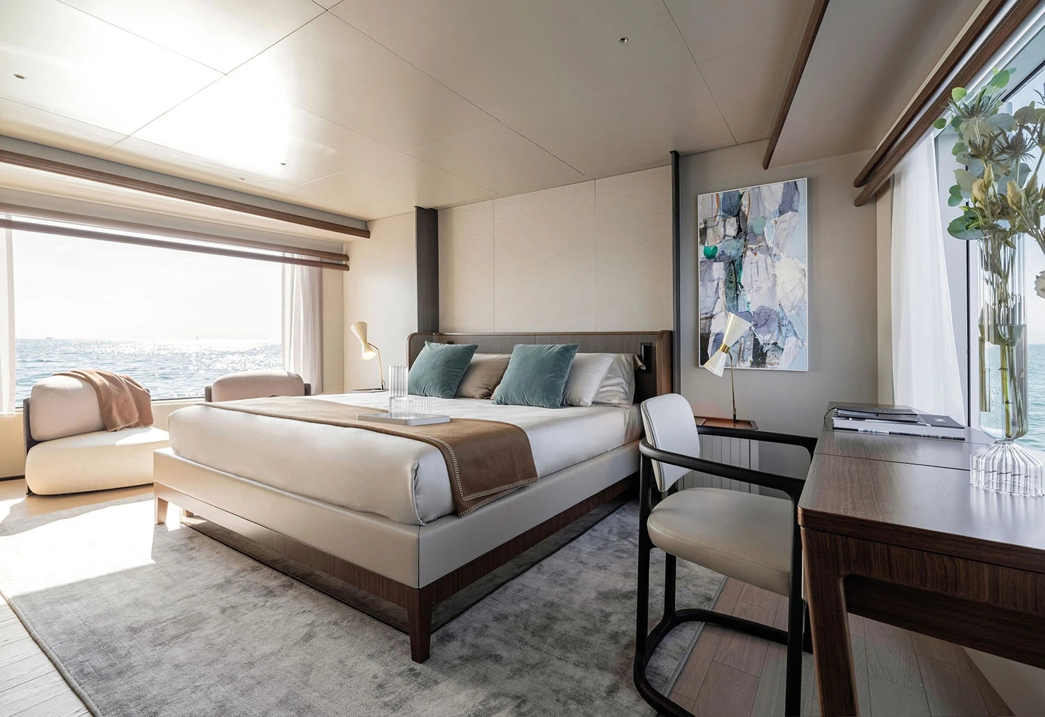 Modern bedroom with a large bed, desk, and large windows.