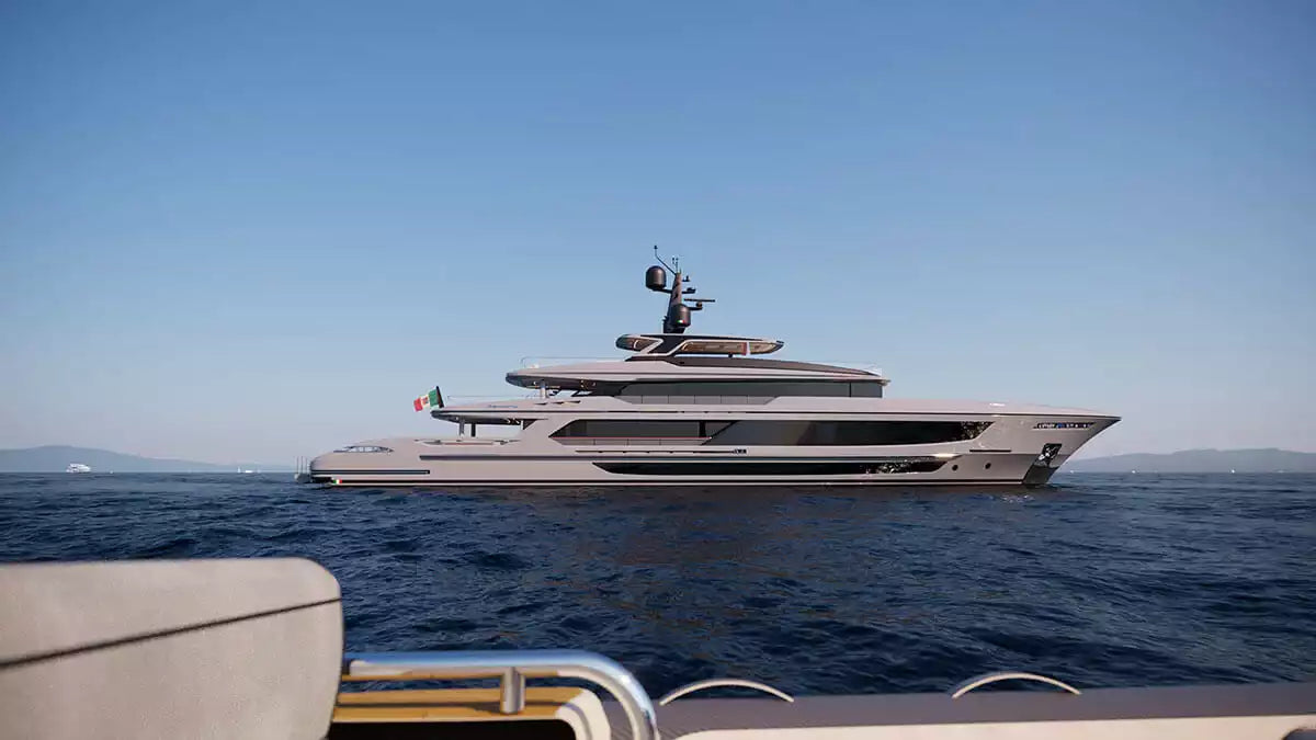 A large luxury yacht with a gray and white exterior sails on deep blue ocean water under a clear blue sky, viewed from the deck of another boat.