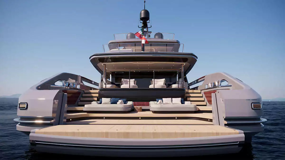 Front view of a luxury superyacht floating on calm blue water under a clear sky, showing a spacious open deck, lounge seating, and upper deck with a flag mounted on the mast.