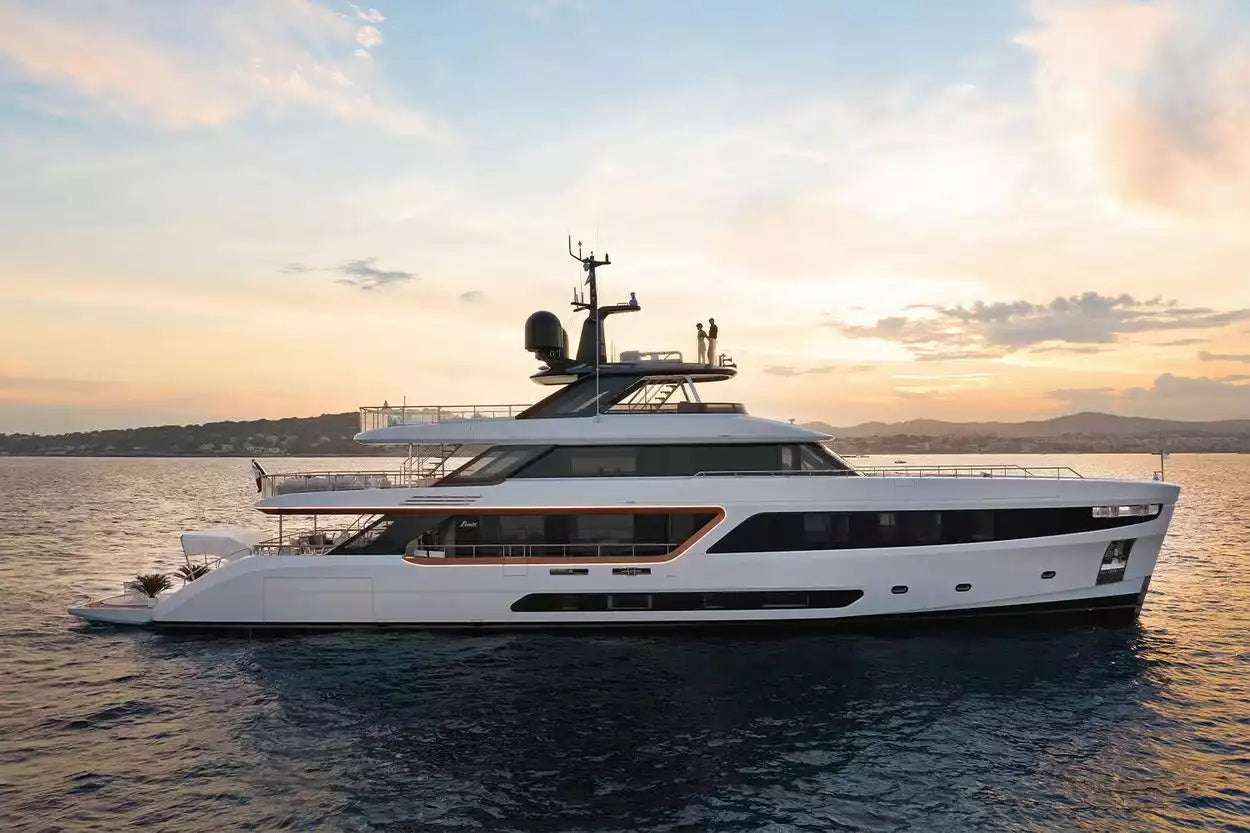 Large white yacht on the water with a sunset sky