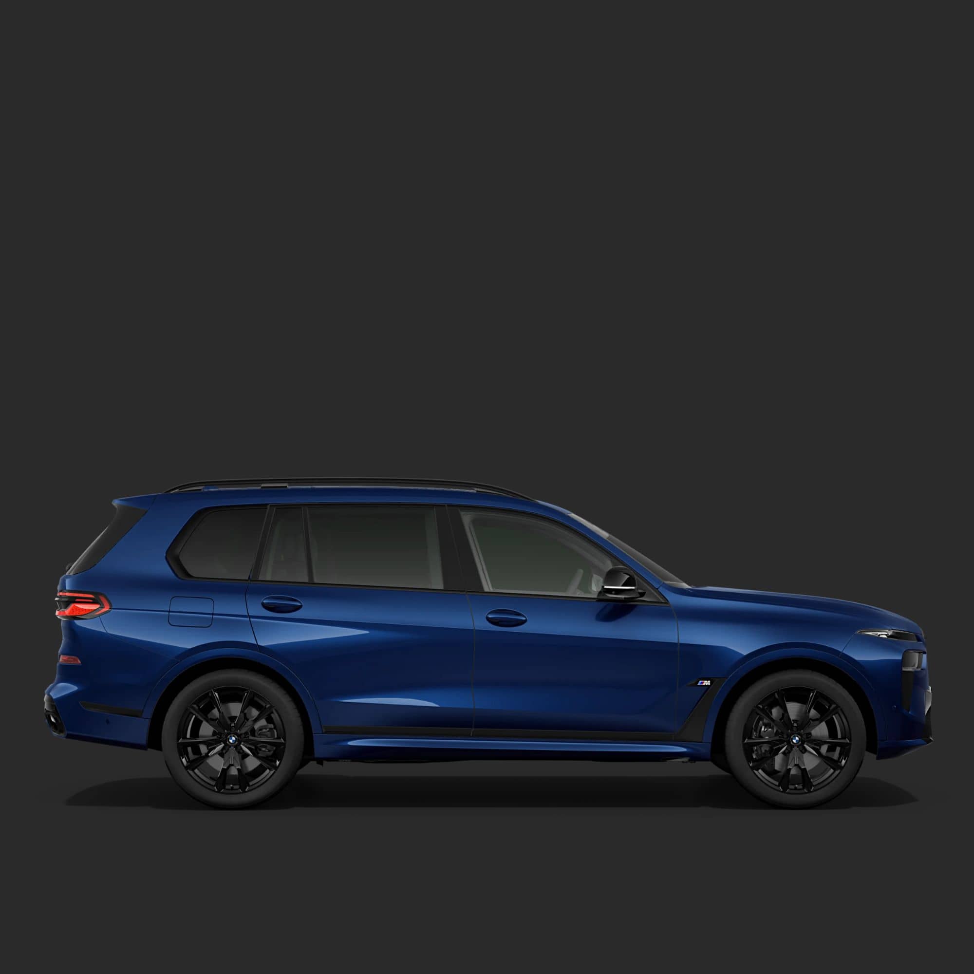 A side profile view of a metallic blue BMW SUV with black wheels, shown against a solid dark gray background.