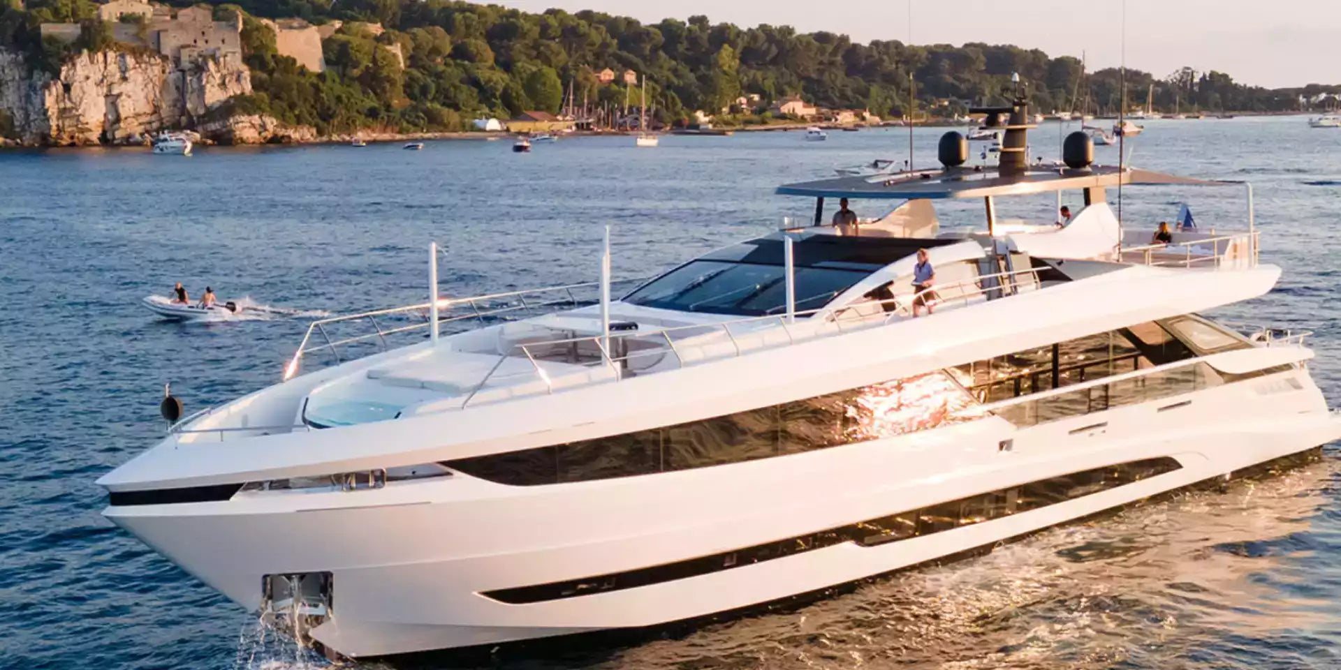 White yacht on a body of water with a scenic background