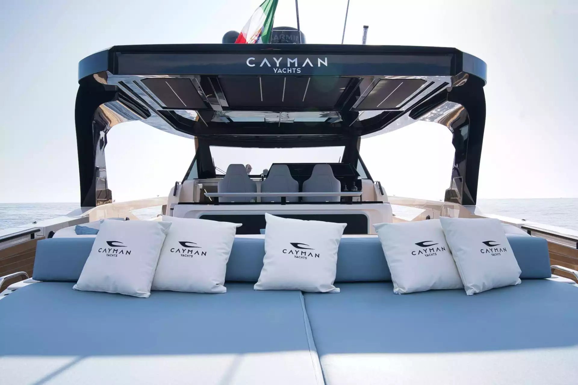 Yacht interior with 'Cayman Yachts' branding on cushions and dashboard.