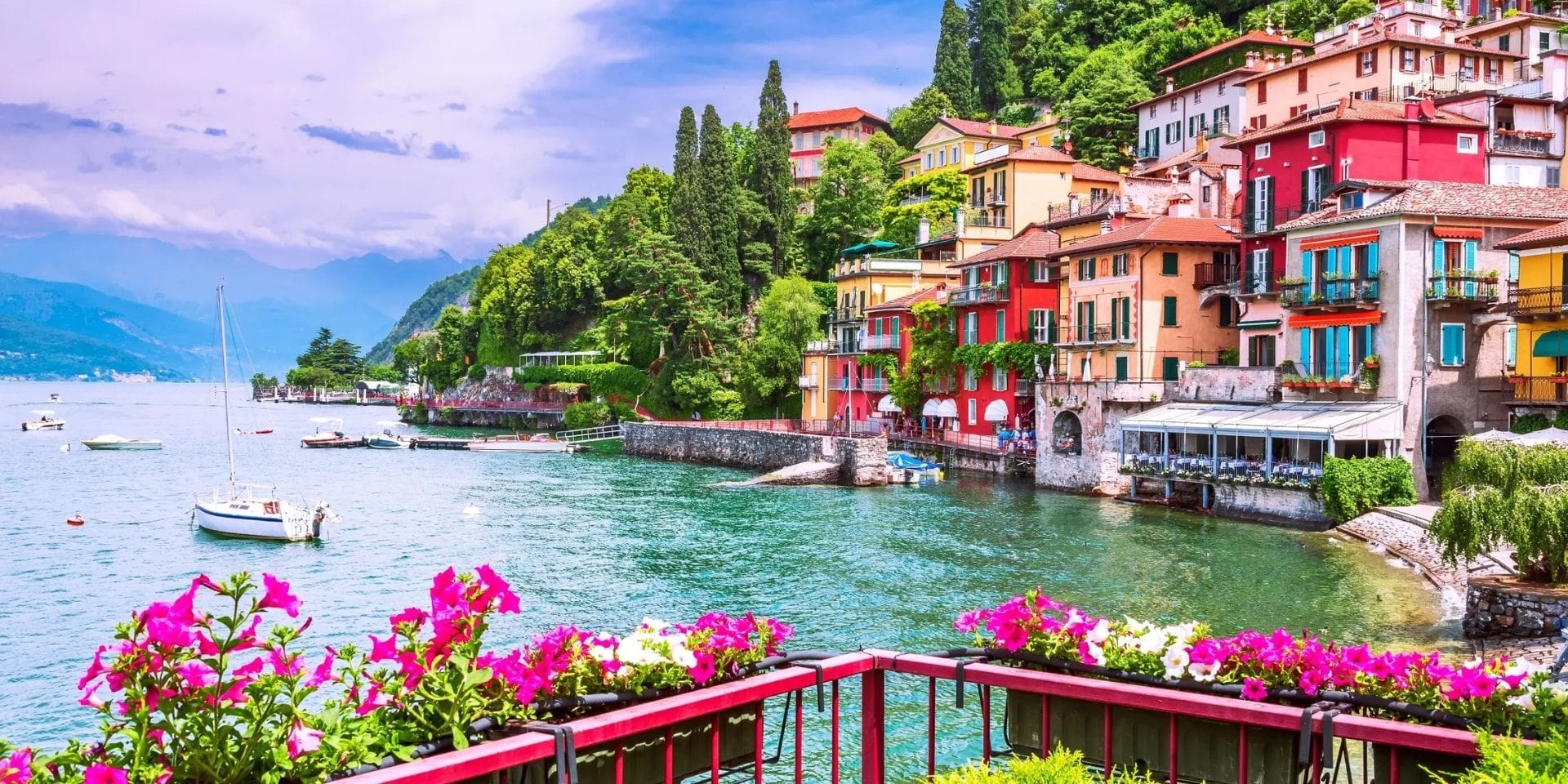 Village by a lake with colorful buildings and boats on a clear day