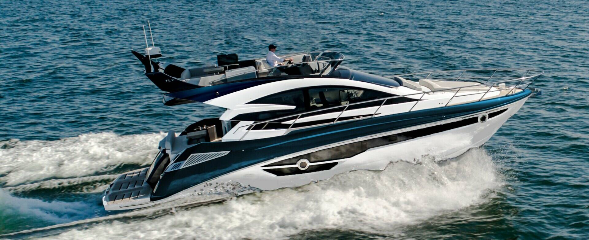 Luxury yacht speeding across the water with a person on board.