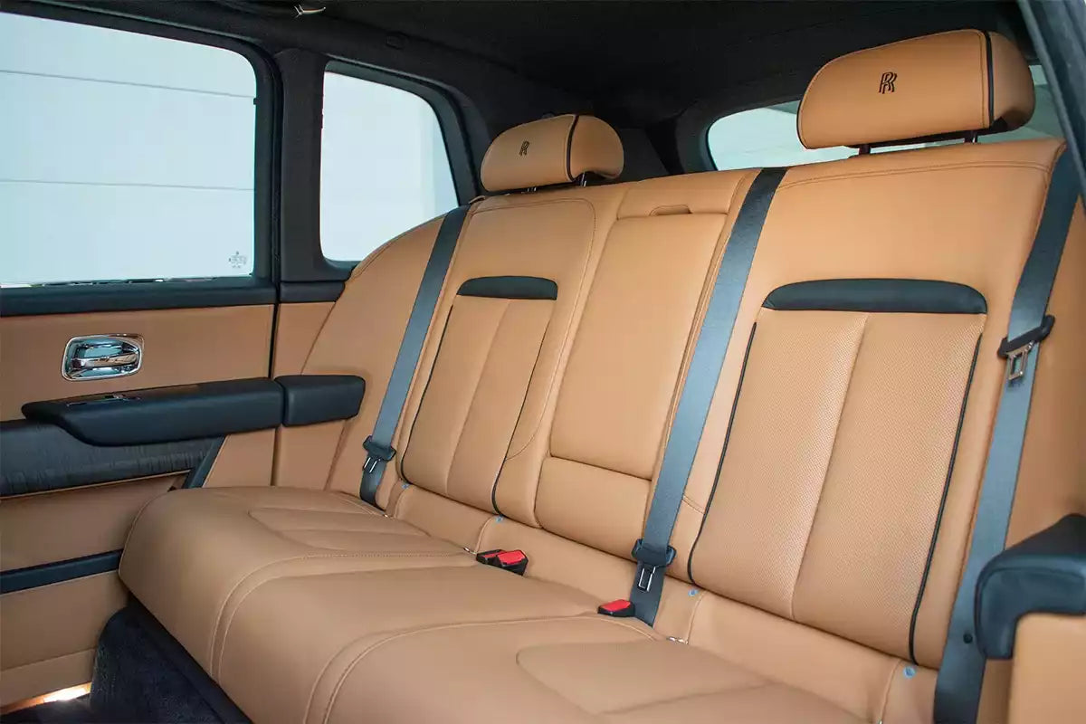 Beige car interior with leather seats and headrests.