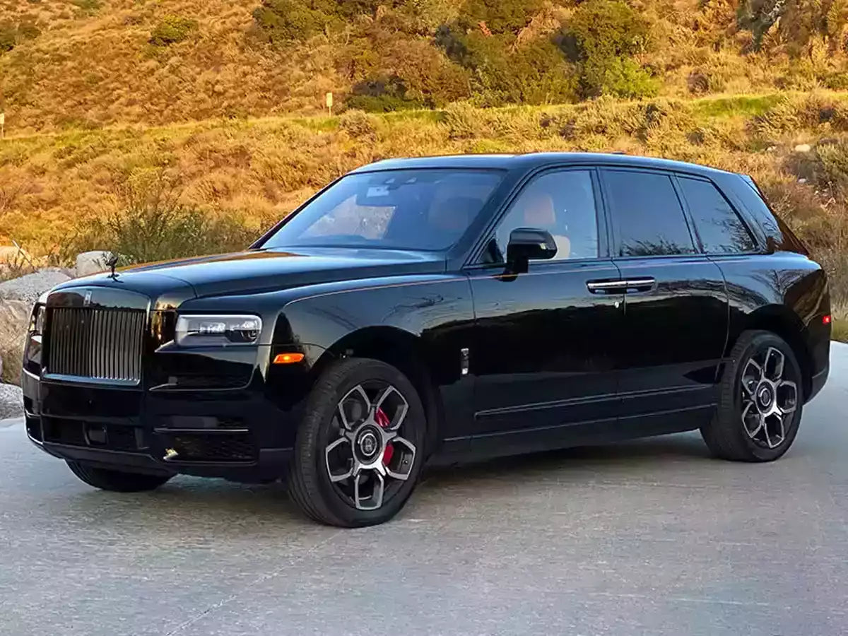 Black luxury SUV parked on a road with a scenic background