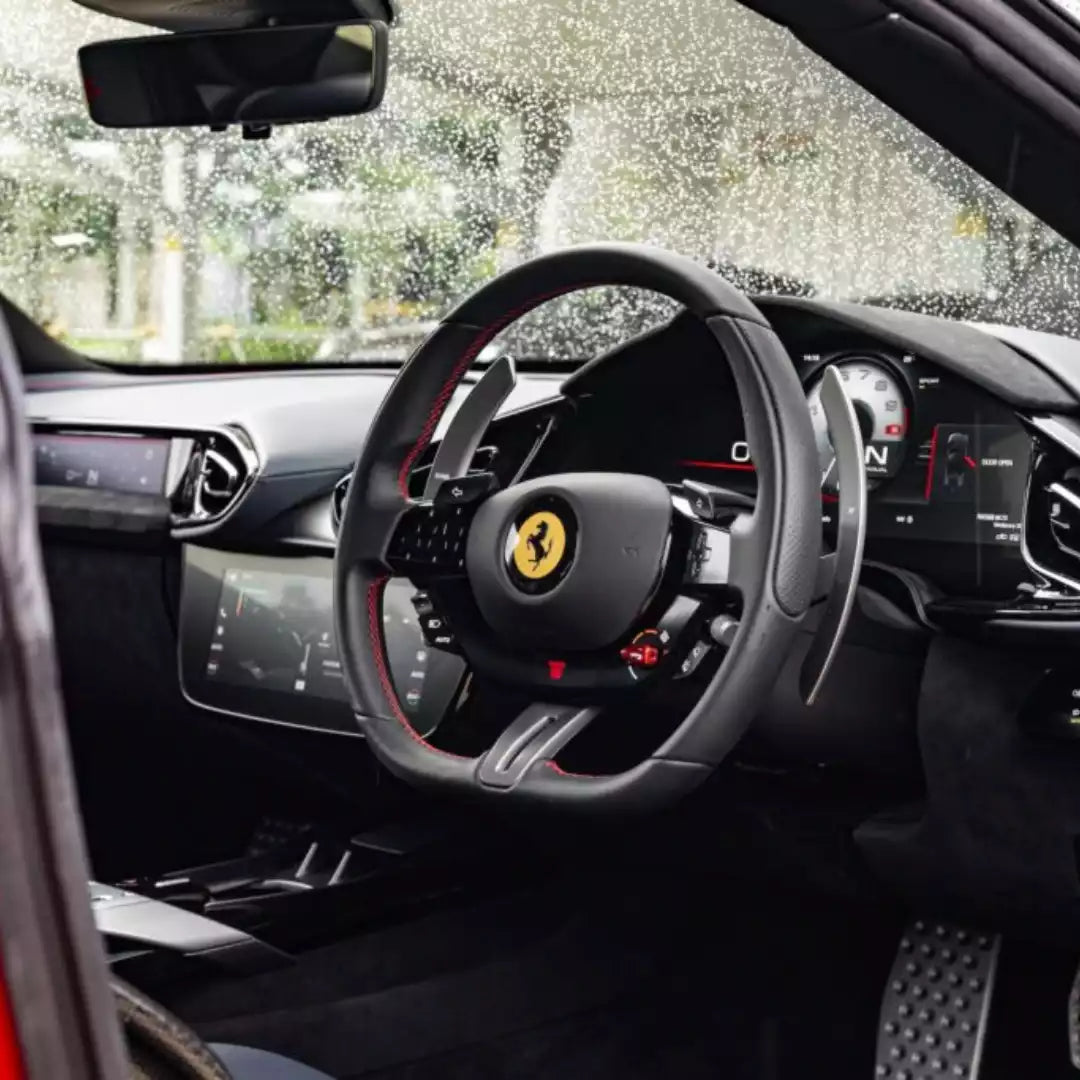 Steering wheel of a Ferrari with dashboard in the background