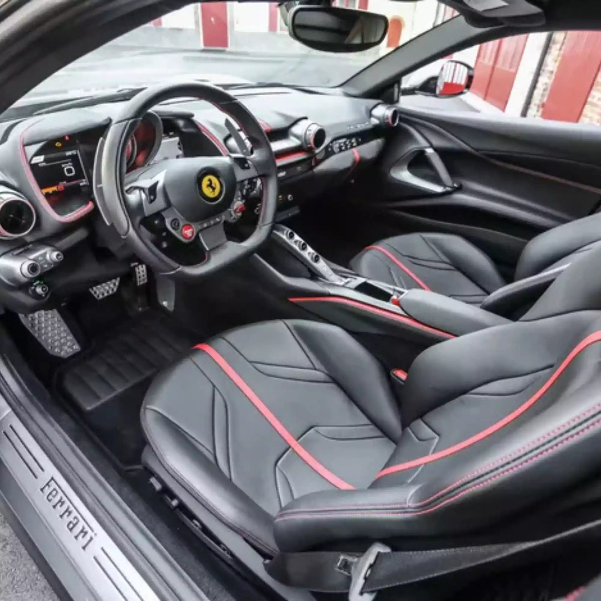 Interior of a Ferrari car with black and red seats.