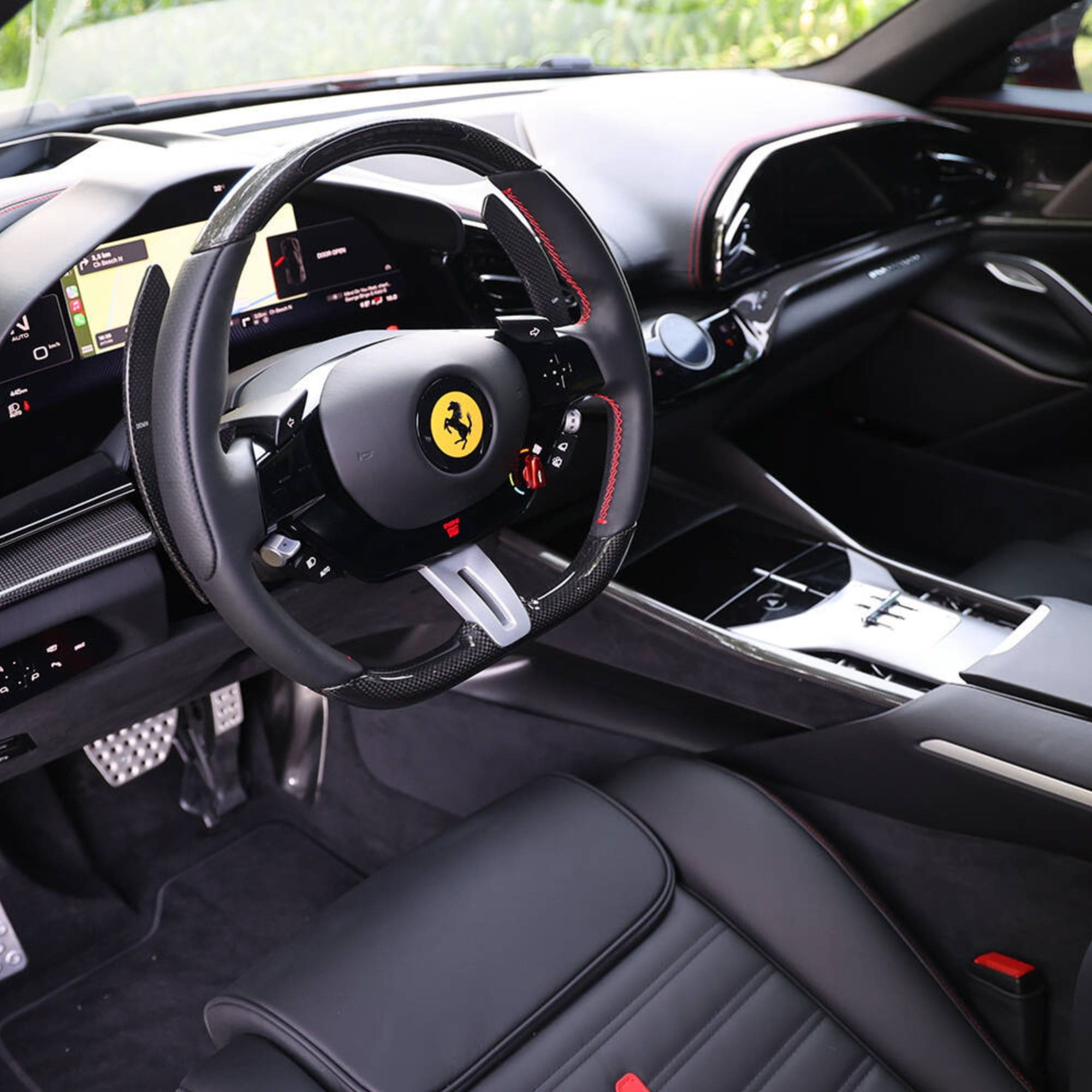 Luxury car interior with steering wheel featuring Ferrari logo