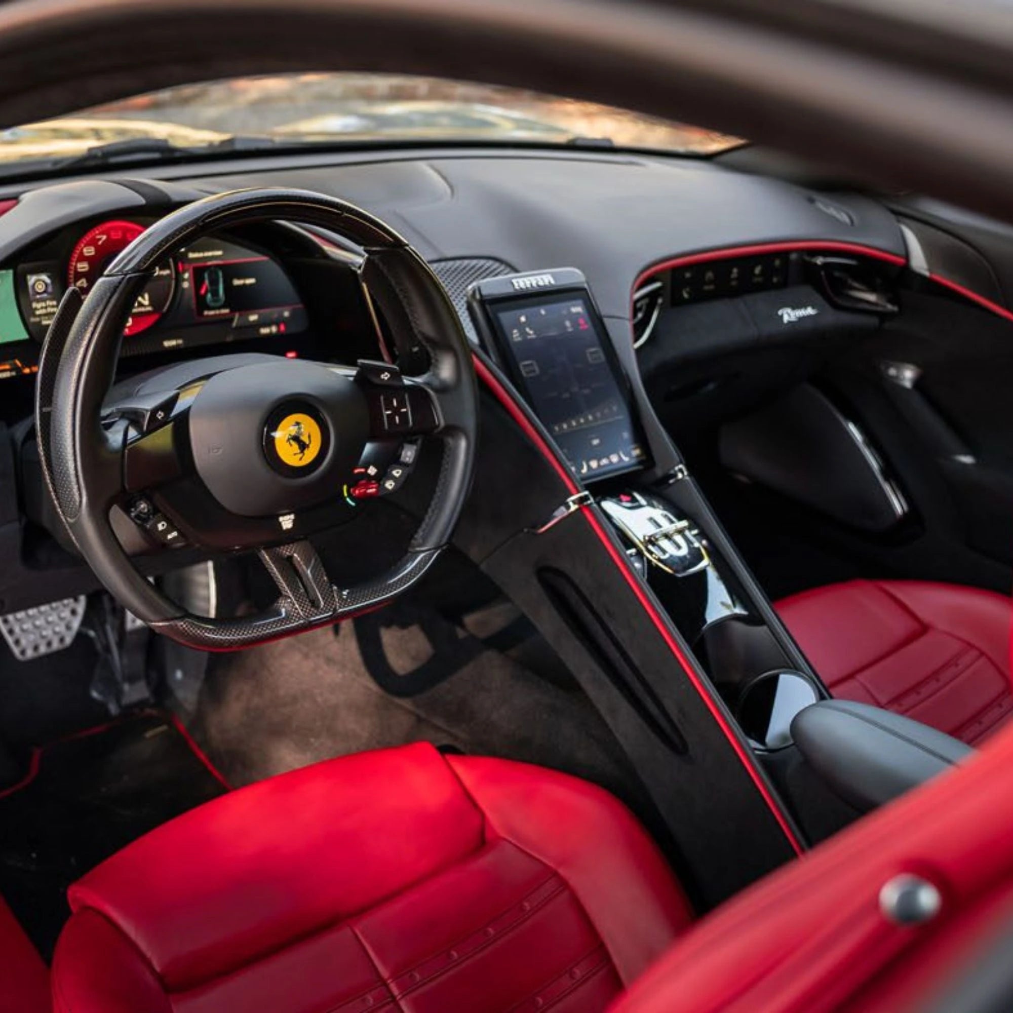Interior of a luxury sports car with red seats and steering wheel.