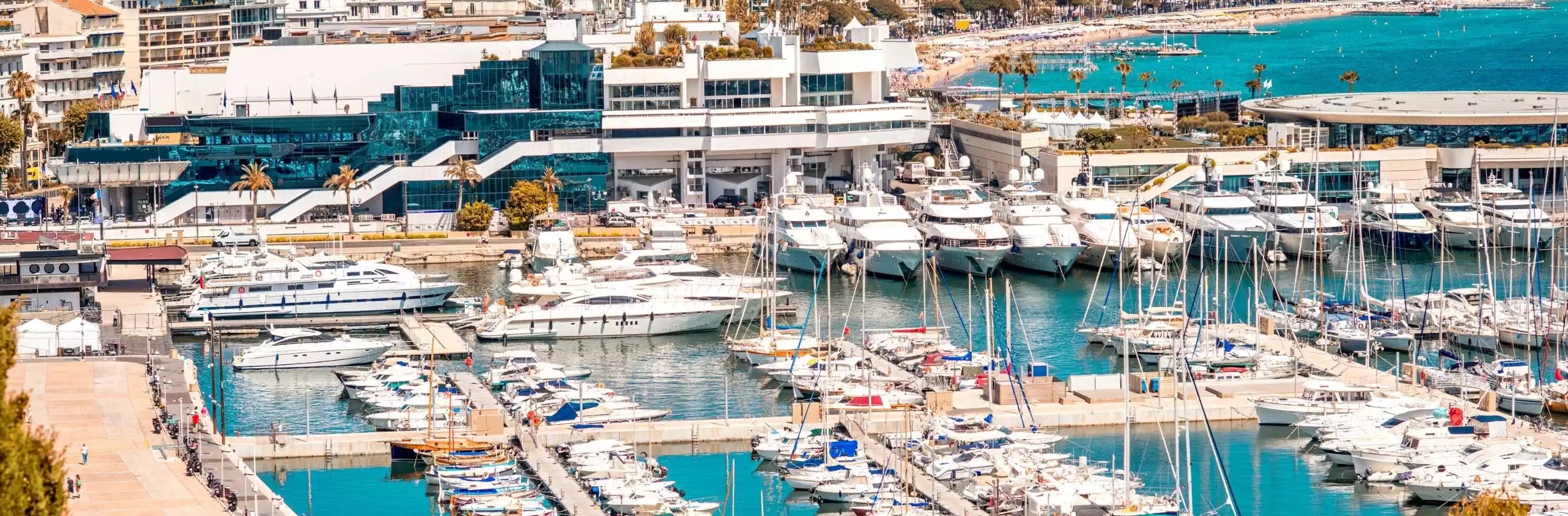 Marina with docked yachts and modern buildings in the background