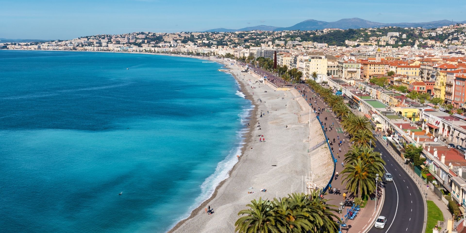 Aerial view of a coastal city with a beach and clear blue water