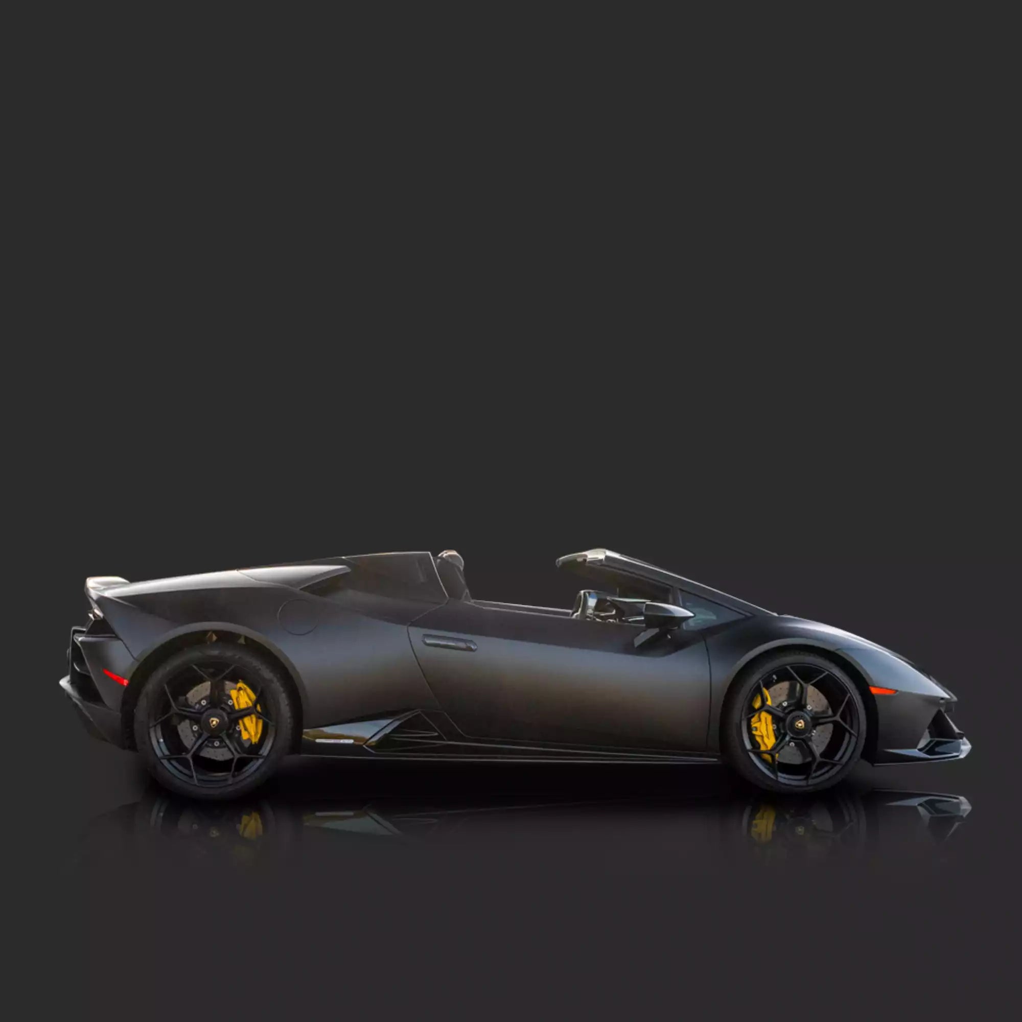 Side view of a black sports car on a dark background
