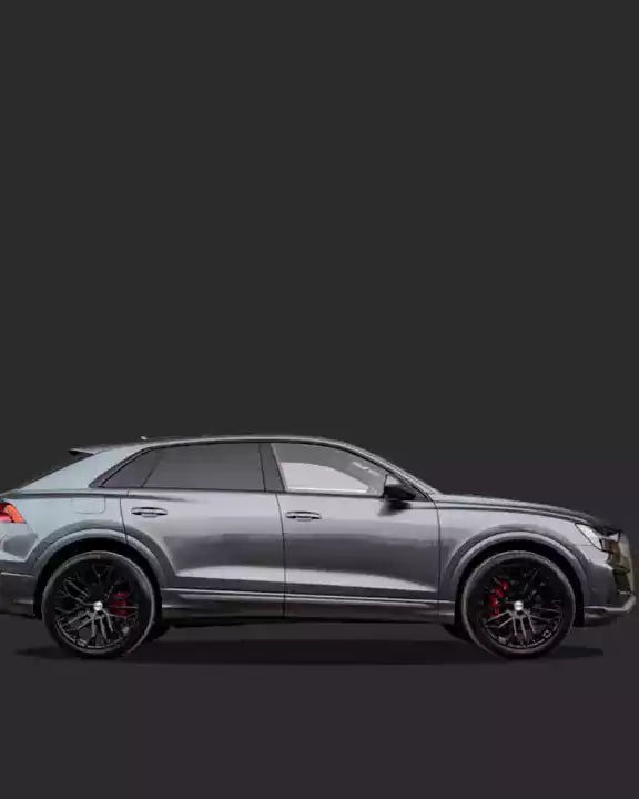 Side view of a silver SUV with black rims on a dark background