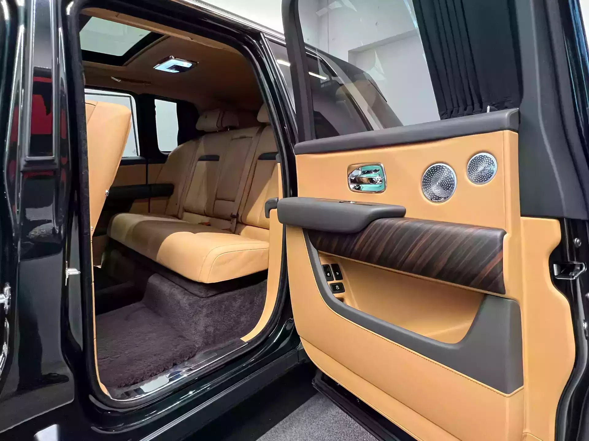 Luxury car interior with beige leather seats and door panel.