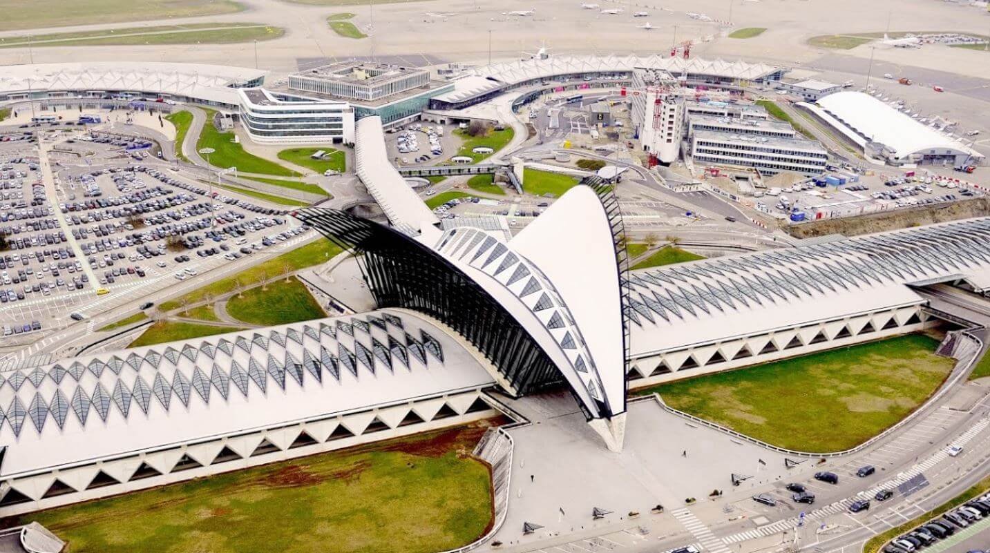 Aerial view of a modern airport terminal with distinctive architecture.