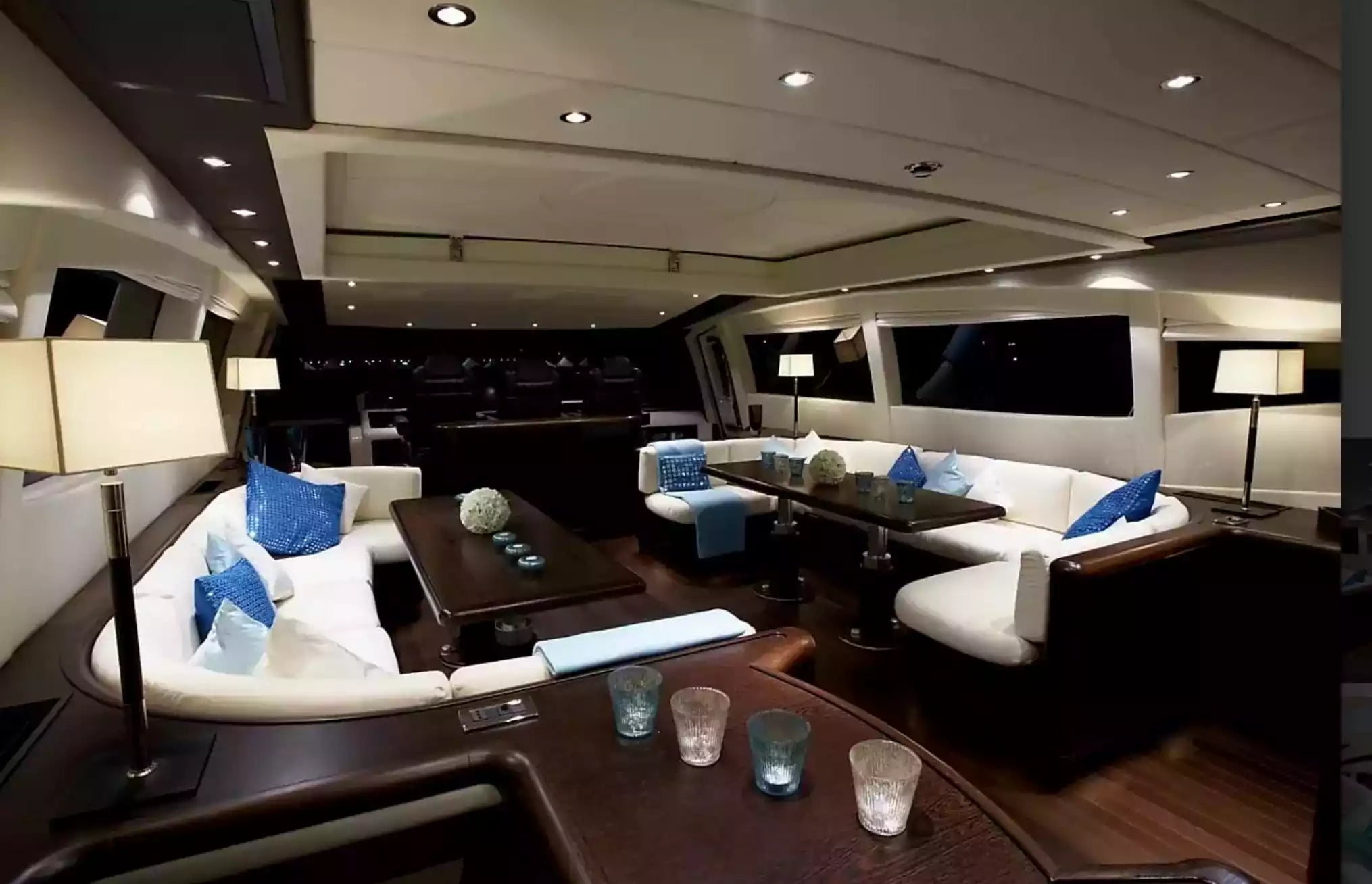 Luxury yacht interior with seating area and tables.