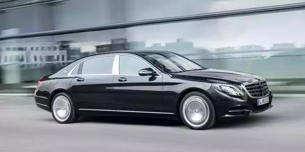 Black Mercedes-Benz car driving on a road with blurred background