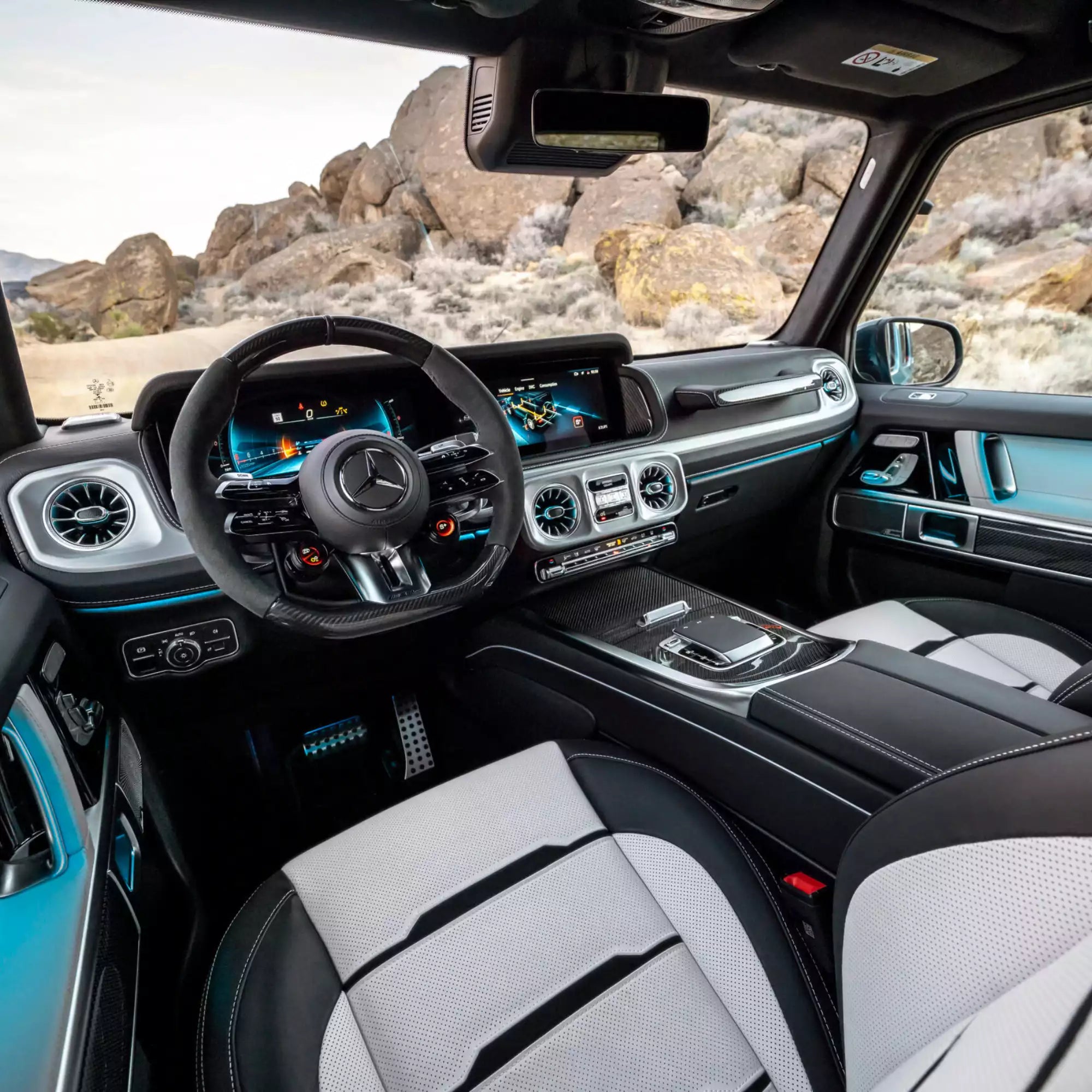 Luxury vehicle interior with steering wheel and dashboard in a desert landscape
