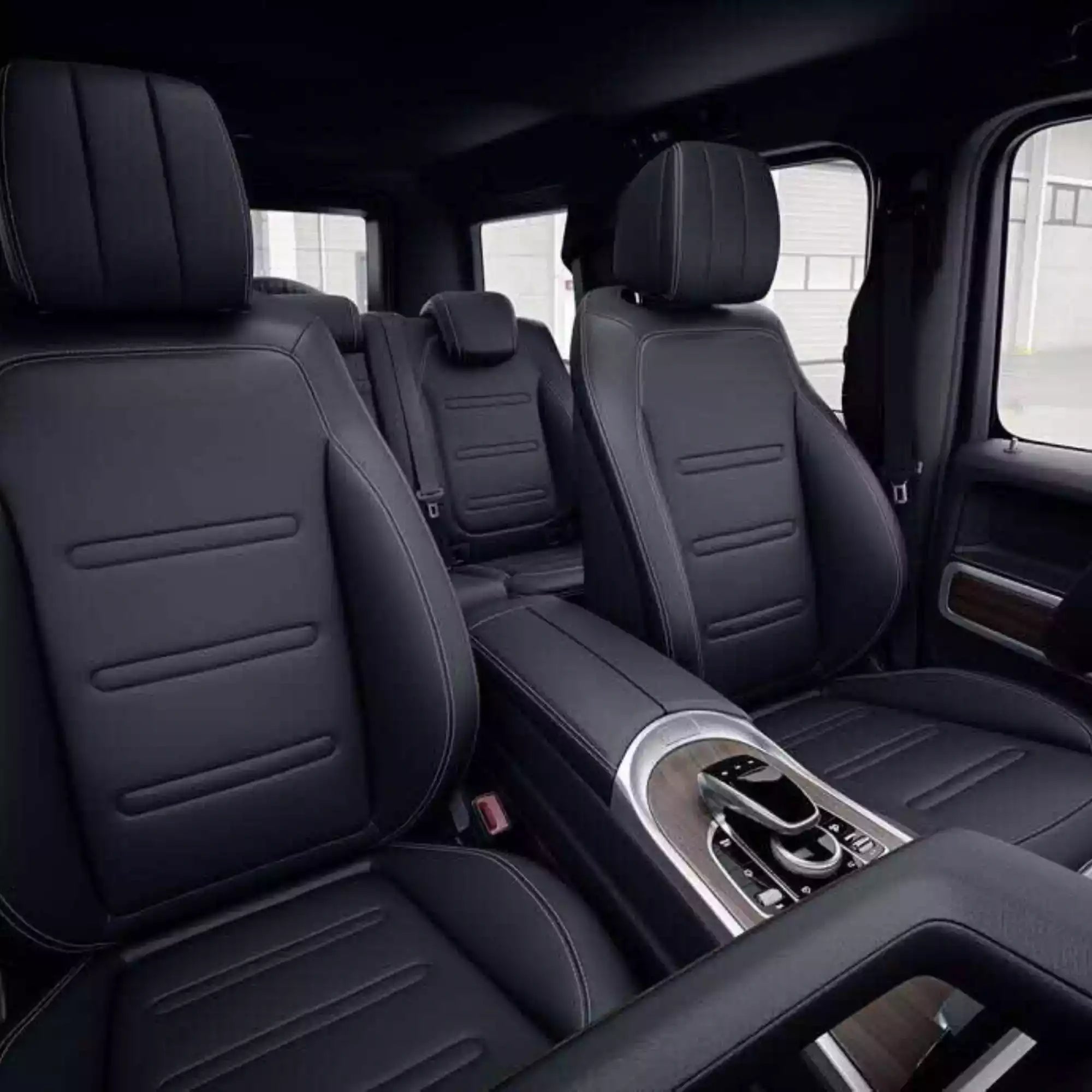 Black leather interior of a vehicle with visible controls and windows.