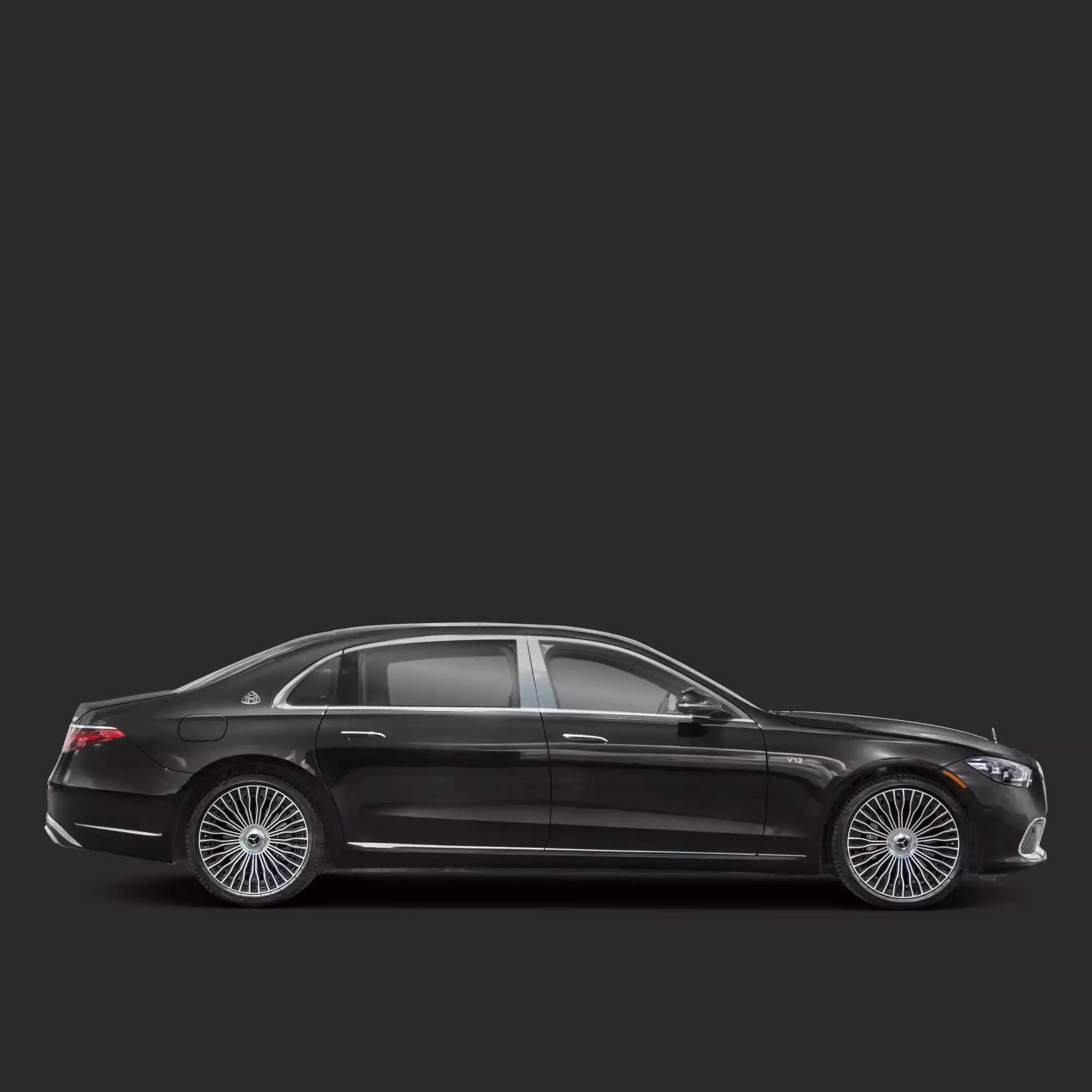 Side view of a black luxury sedan on a dark background