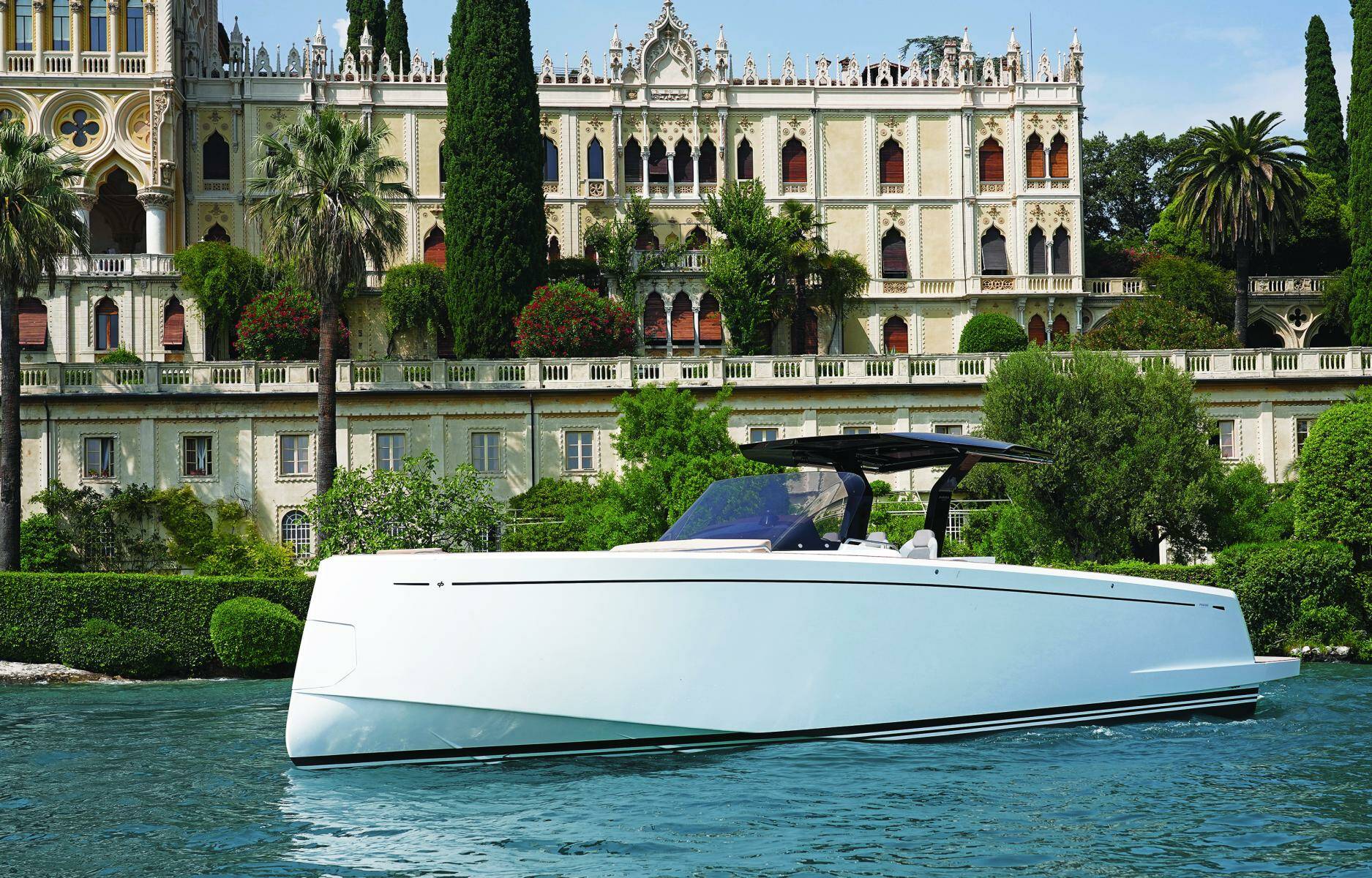 White yacht on water with a grand building in the background