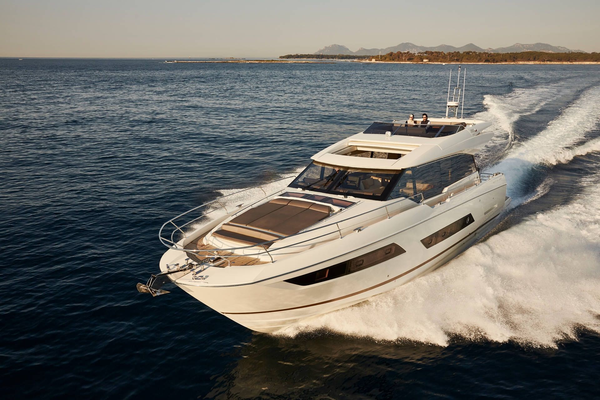 White yacht speeding on the water with a clear sky