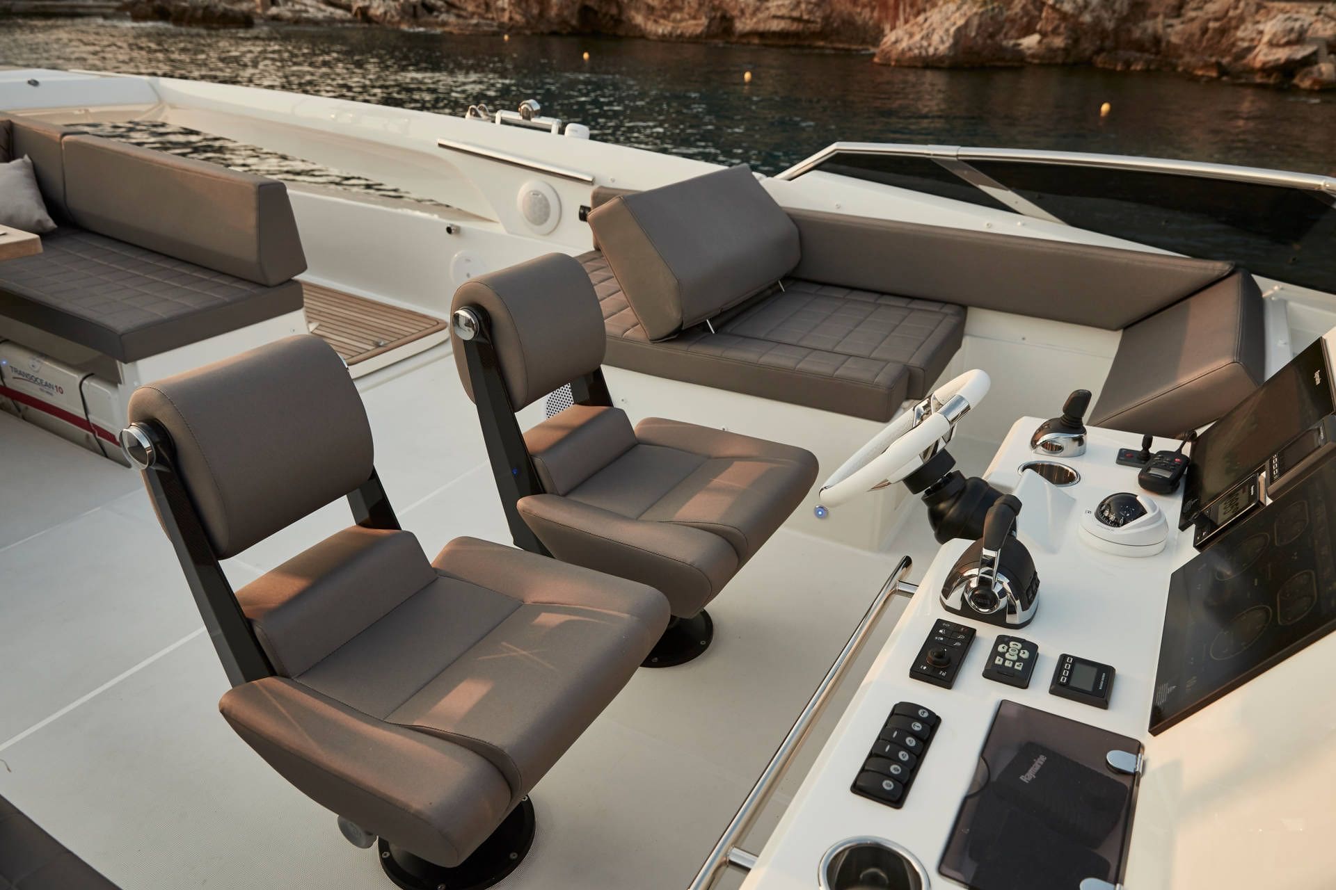 Interior of a luxurious boat with gray leather seats and control panel.