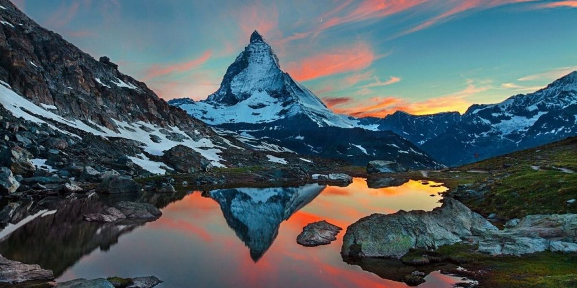 Mountain peak reflected in a lake with a colorful sky