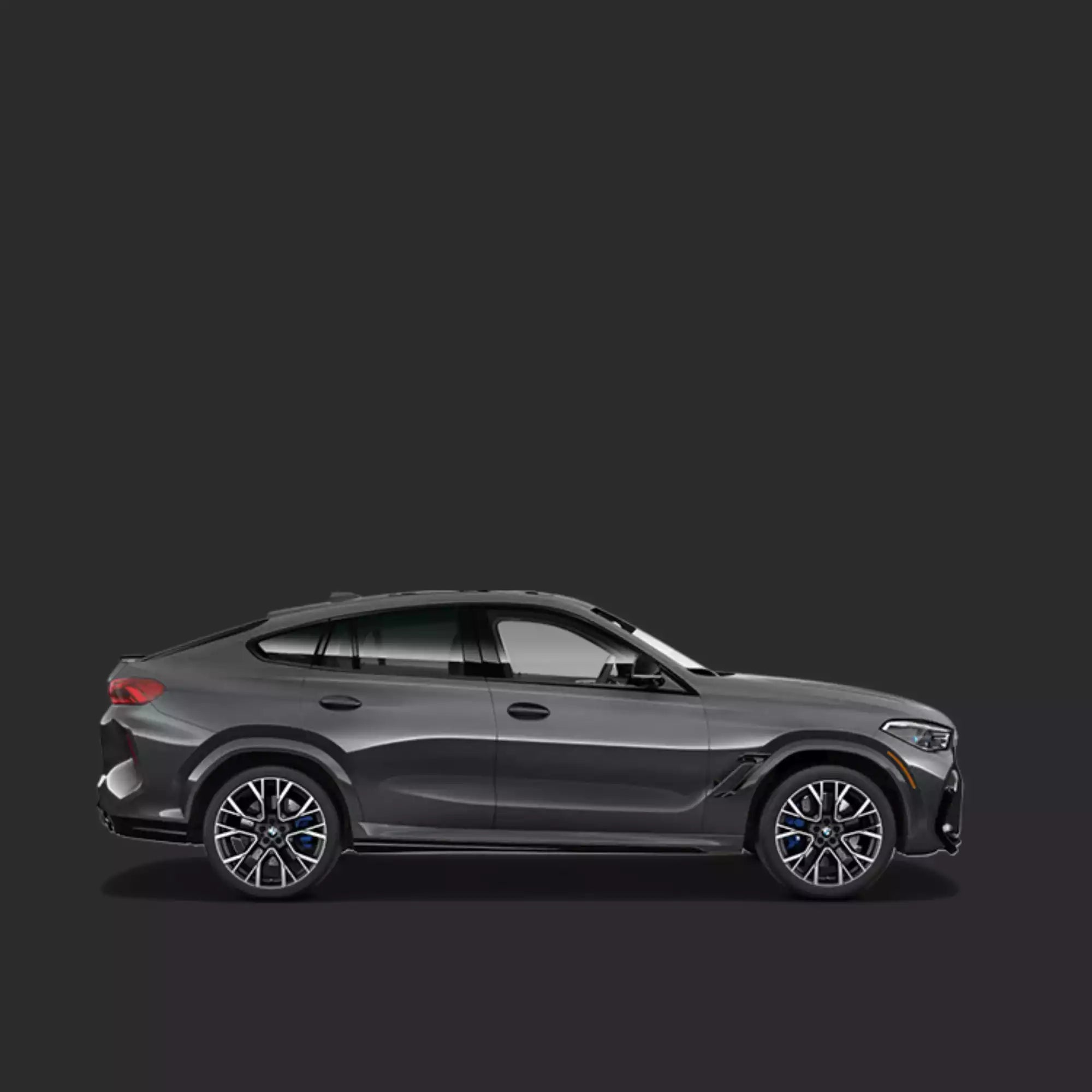 A dark gray BMW X6 SUV shown in a clean side profile against a solid dark gray studio background.