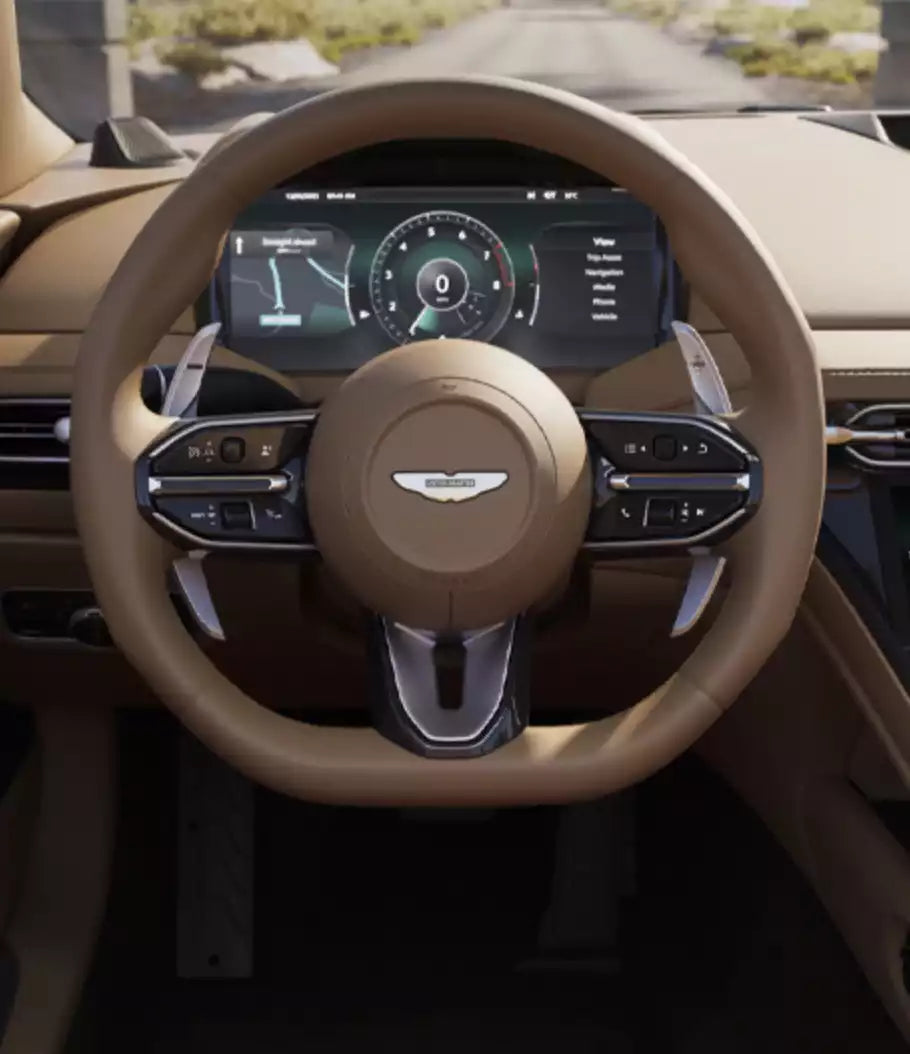 A close-up view of a luxury car's multi-function steering wheel with a tan leather wrap and silver accents, set inside a matching beige interior.